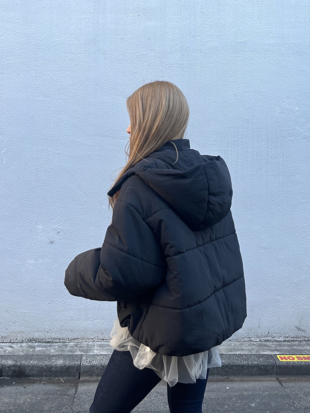 ホワイト系のシャツ/ブラウス、グレー系のニット/セーター、ブルー系のデニムパンツを着用したレディースの冬コーディネートの9枚目の写真