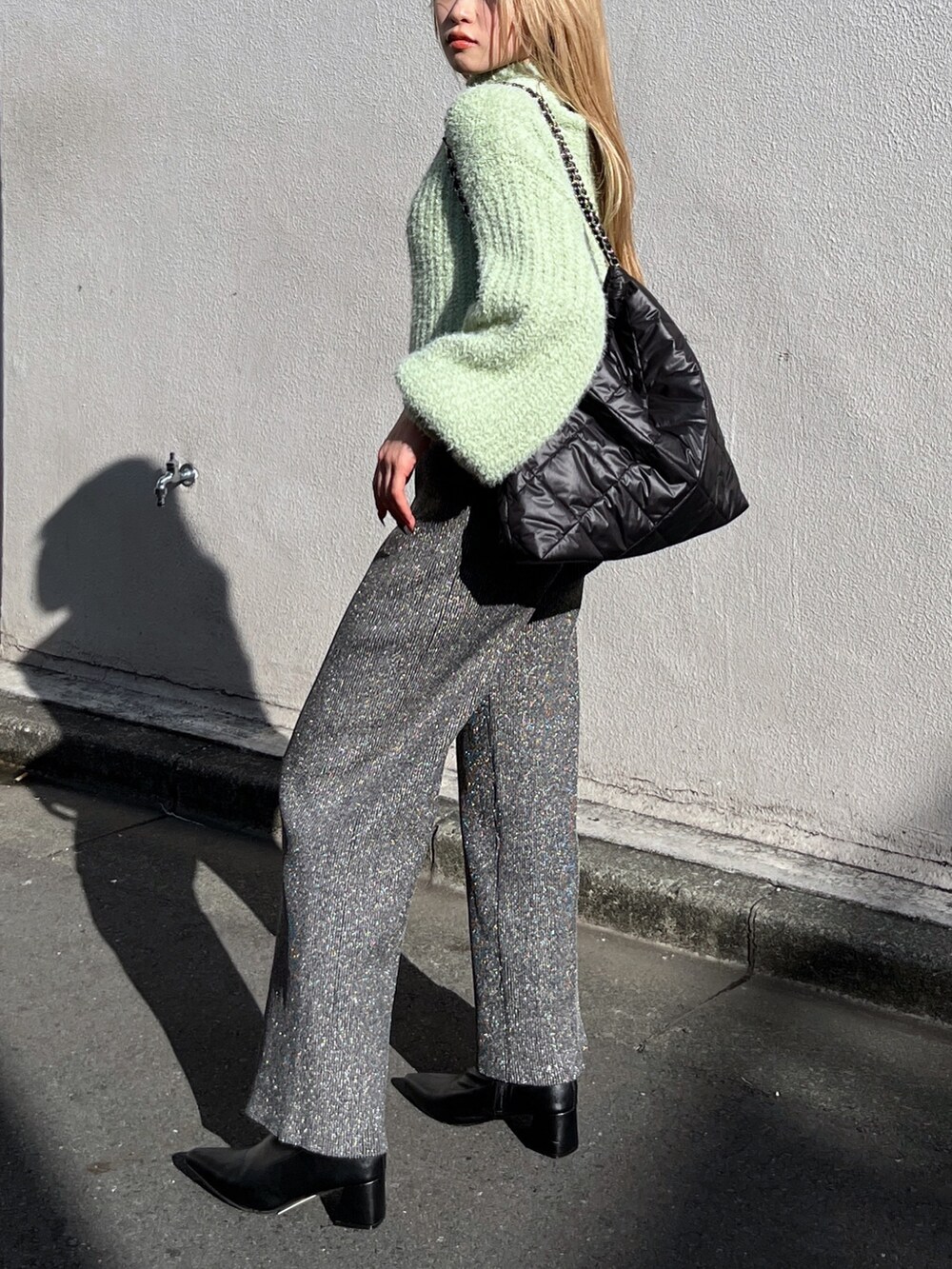 ブラック系のブーツ、ブラック系のその他パンツ、グリーン系のニット/セーターを着用したレディースの冬コーディネートの5枚目の写真