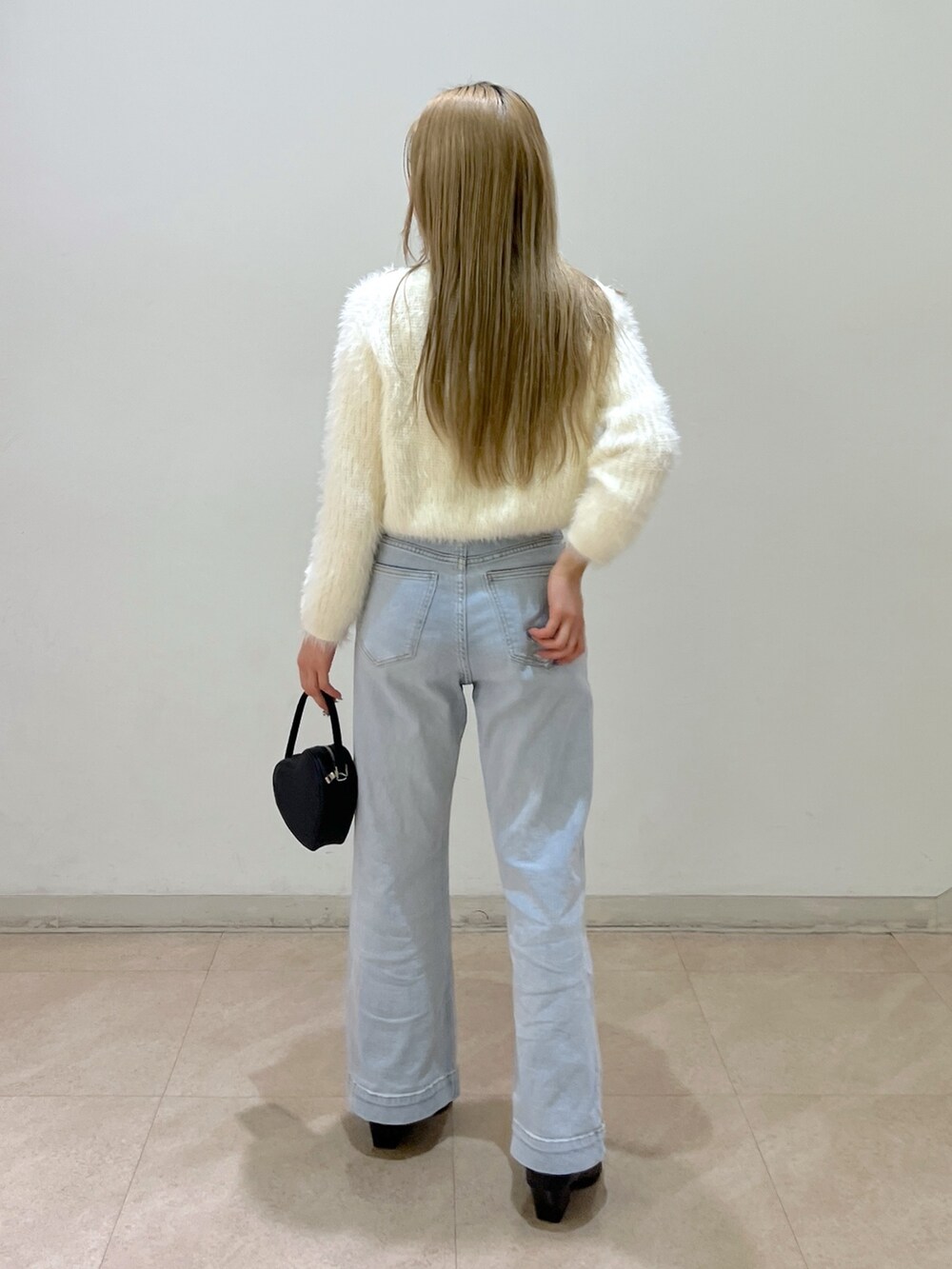 ホワイト系のカーディガン/ボレロ、ブルー系のデニムパンツ、ブラック系のショルダーバッグを着用したレディースの春コーディネートの3枚目の写真