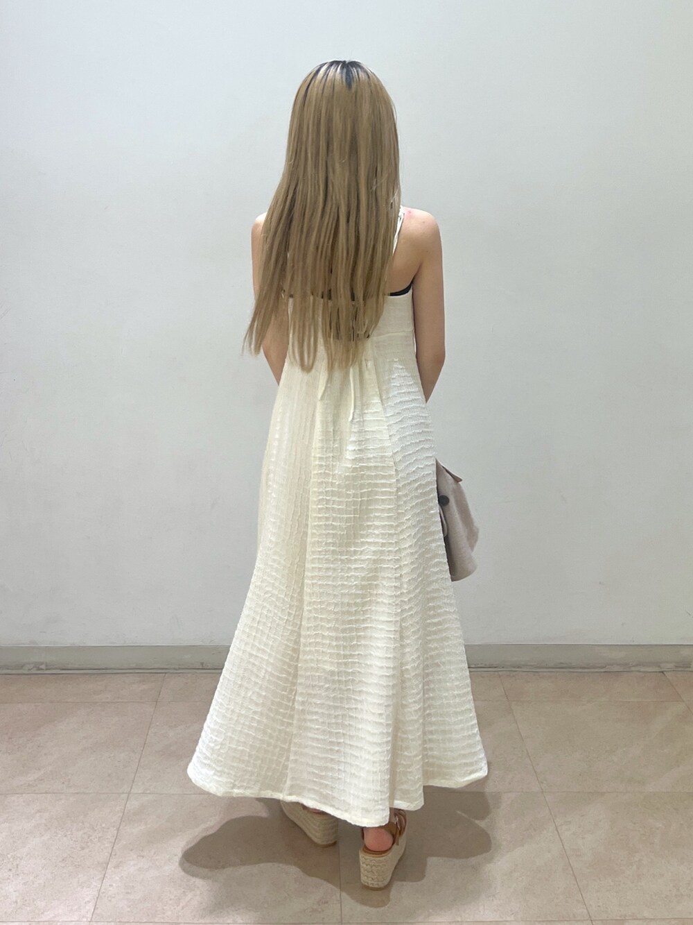 ベージュ系のテーラードジャケット、ブラウン系のショルダーバッグ、ホワイト系のワンピースを着用したレディースの春コーディネートの9枚目の写真