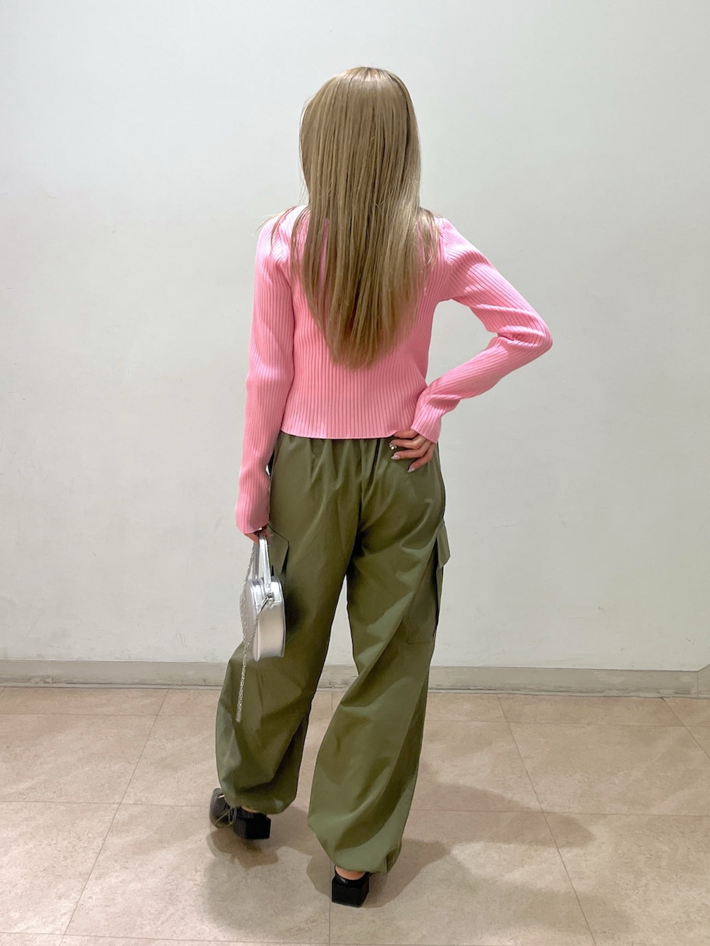 グリーン系のカーゴパンツ、シルバー系のショルダーバッグ、ブラック系のパンプスを着用したレディースの春コーディネートの2枚目の写真