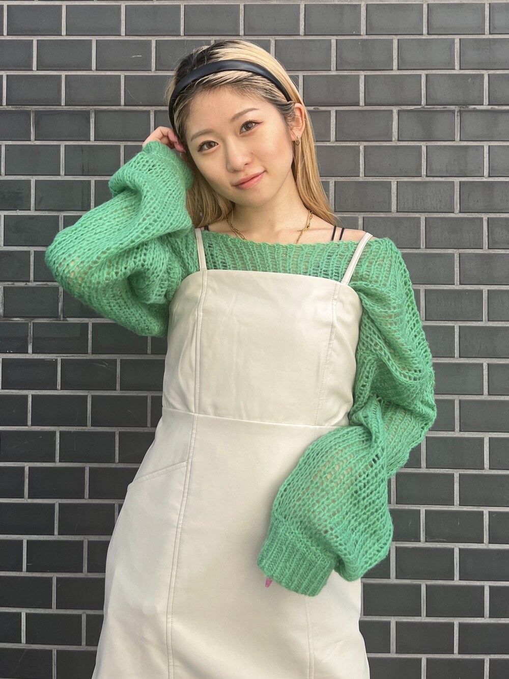 グリーン系のニット/セーター、ホワイト系のワンピース、ホワイト系のブーツを着用したレディースの秋コーディネートの4枚目の写真