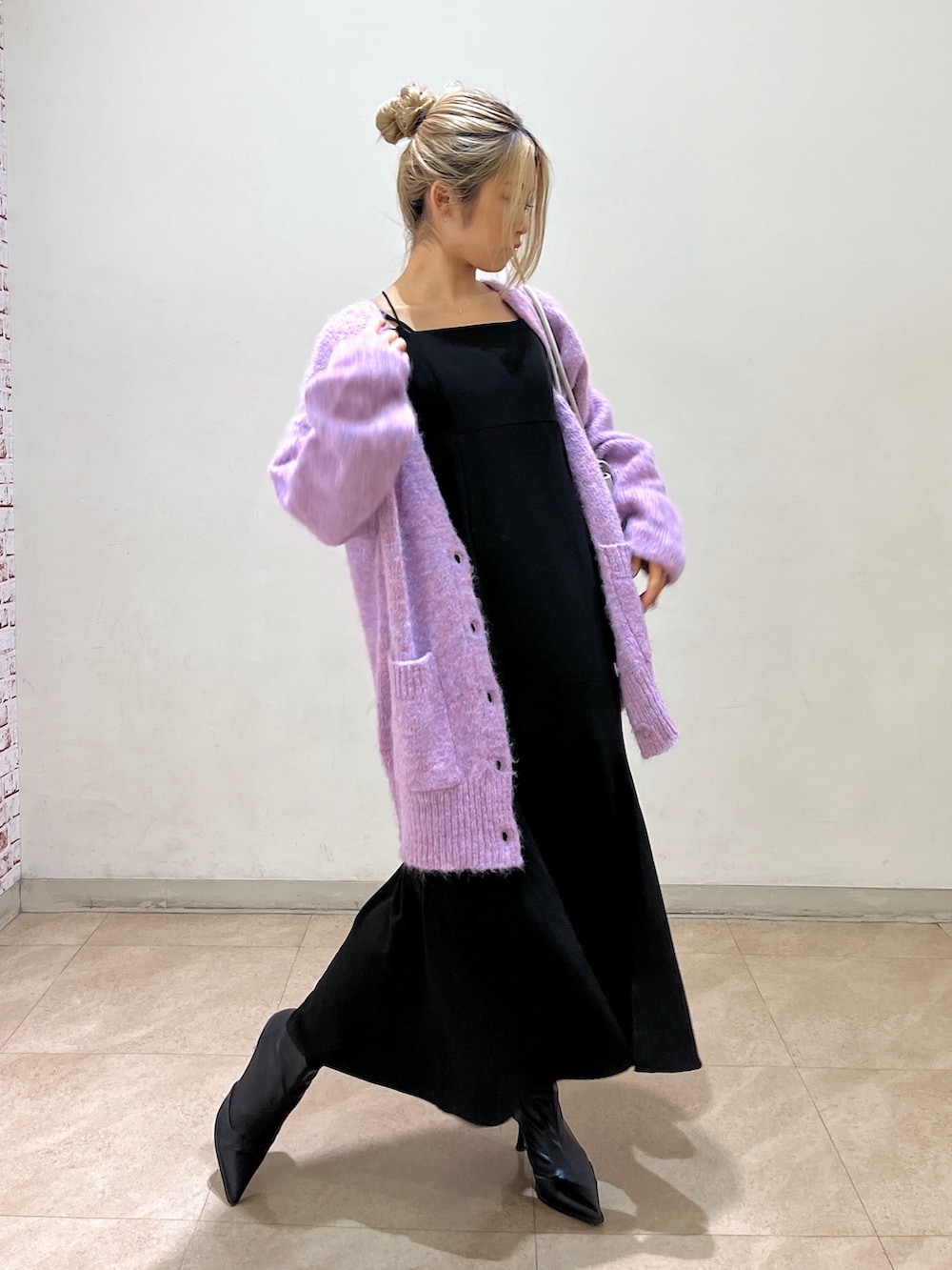 ブラック系のワンピース、パープル系のカーディガン/ボレロ、ホワイト系のショルダーバッグを着用したレディースの冬コーディネートの2枚目の写真