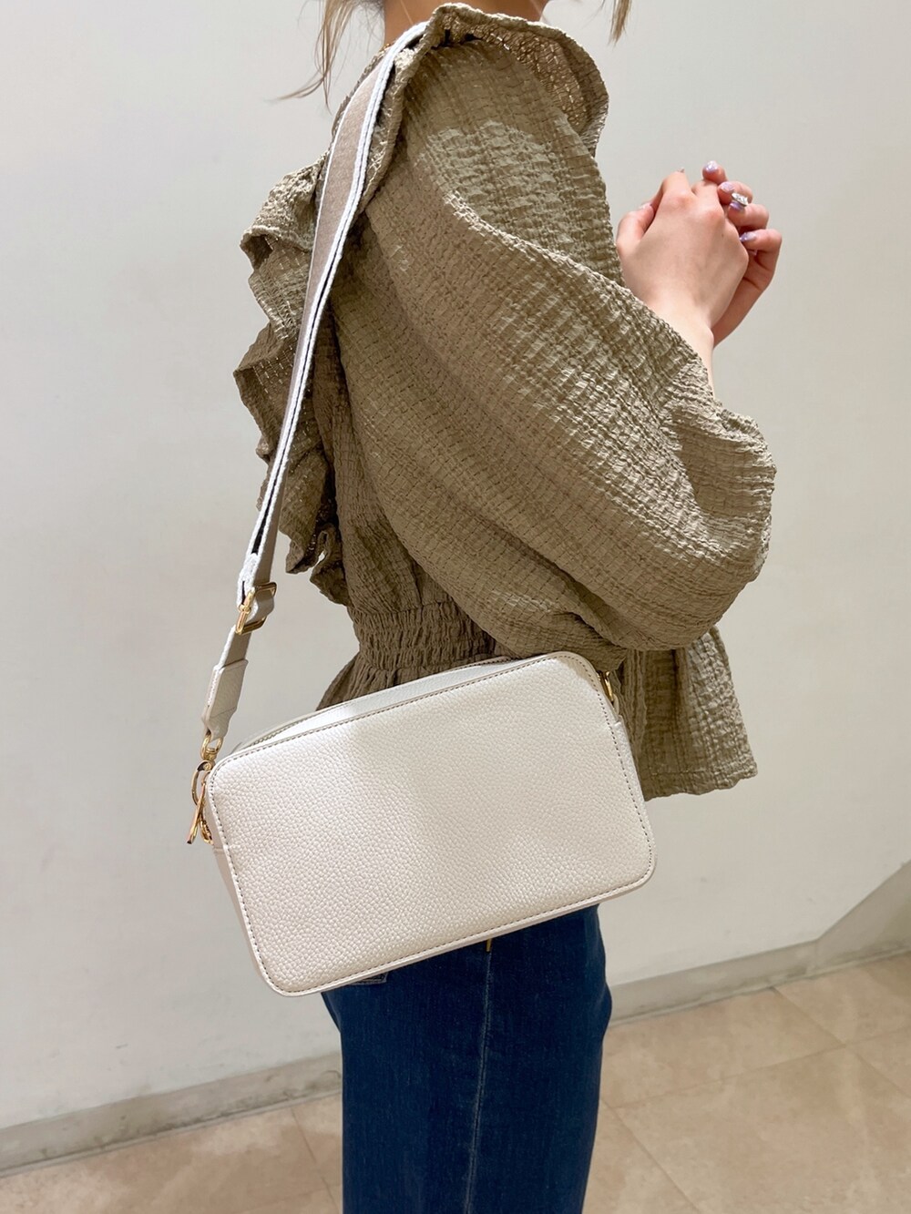 ブラウン系のシャツ/ブラウス、ブルー系のデニムパンツ、ゴールド系のパンプスを着用したレディースの春コーディネートの10枚目の写真