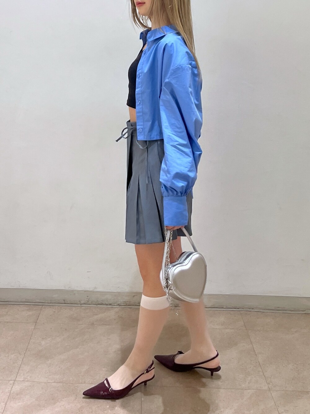 ブルー系のシャツ/ブラウス、グレー系のスカート、シルバー系のショルダーバッグを着用したレディースの春コーディネートの2枚目の写真