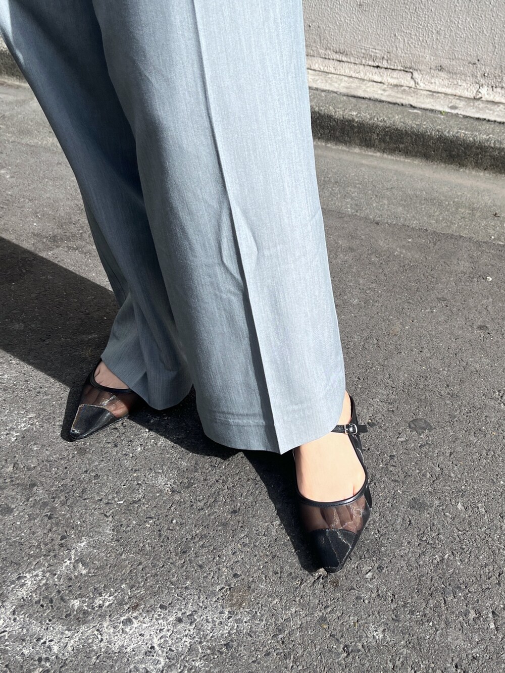 ブルー系のニット/セーター、シルバー系のショルダーバッグ、グレー系のスラックスを着用したレディースの春コーディネートの10枚目の写真