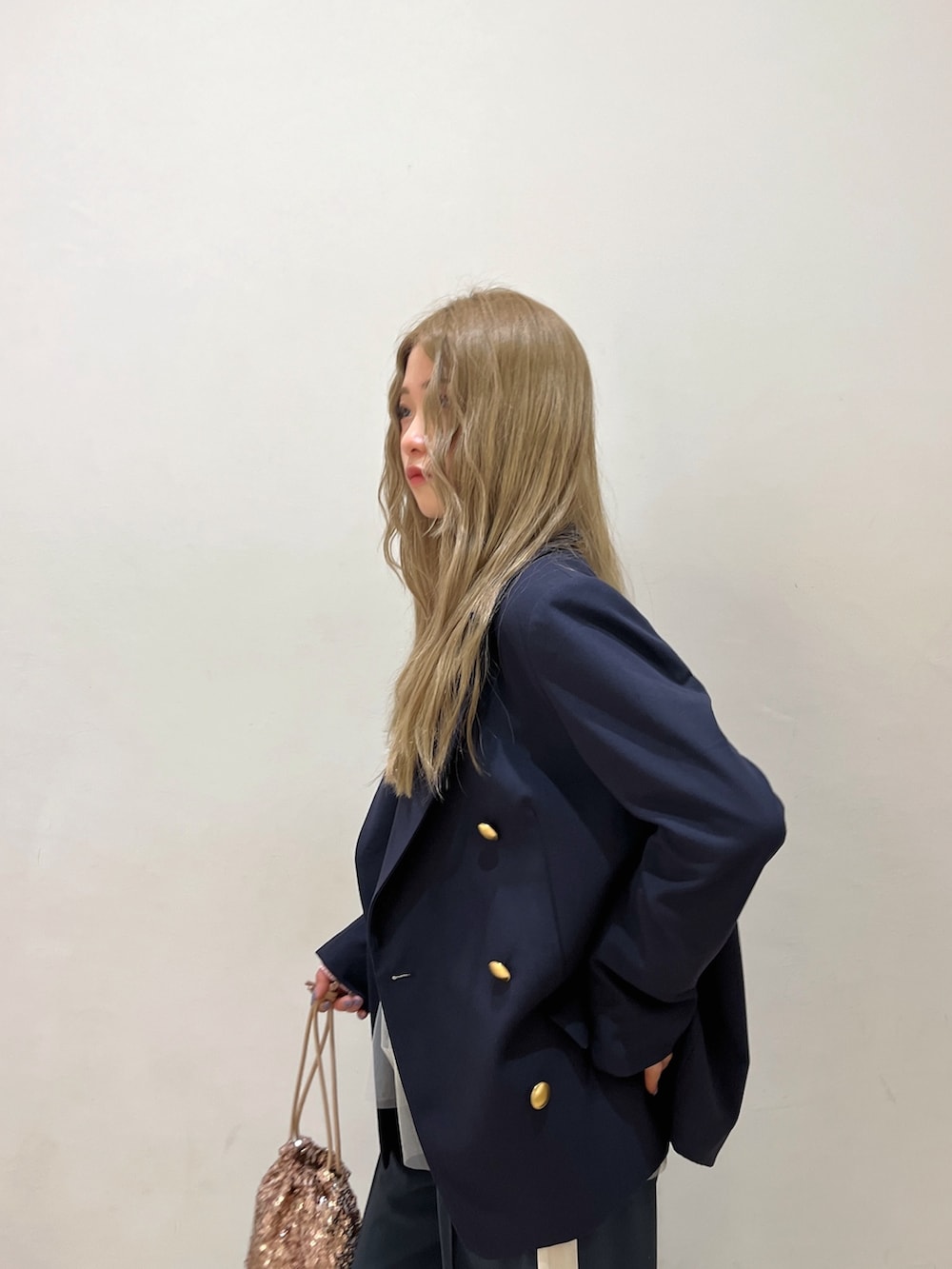 ブルー系のテーラードジャケット、ピンク系のニット/セーター、シルバー系のハンドバッグを着用したレディースの冬コーディネートの6枚目の写真