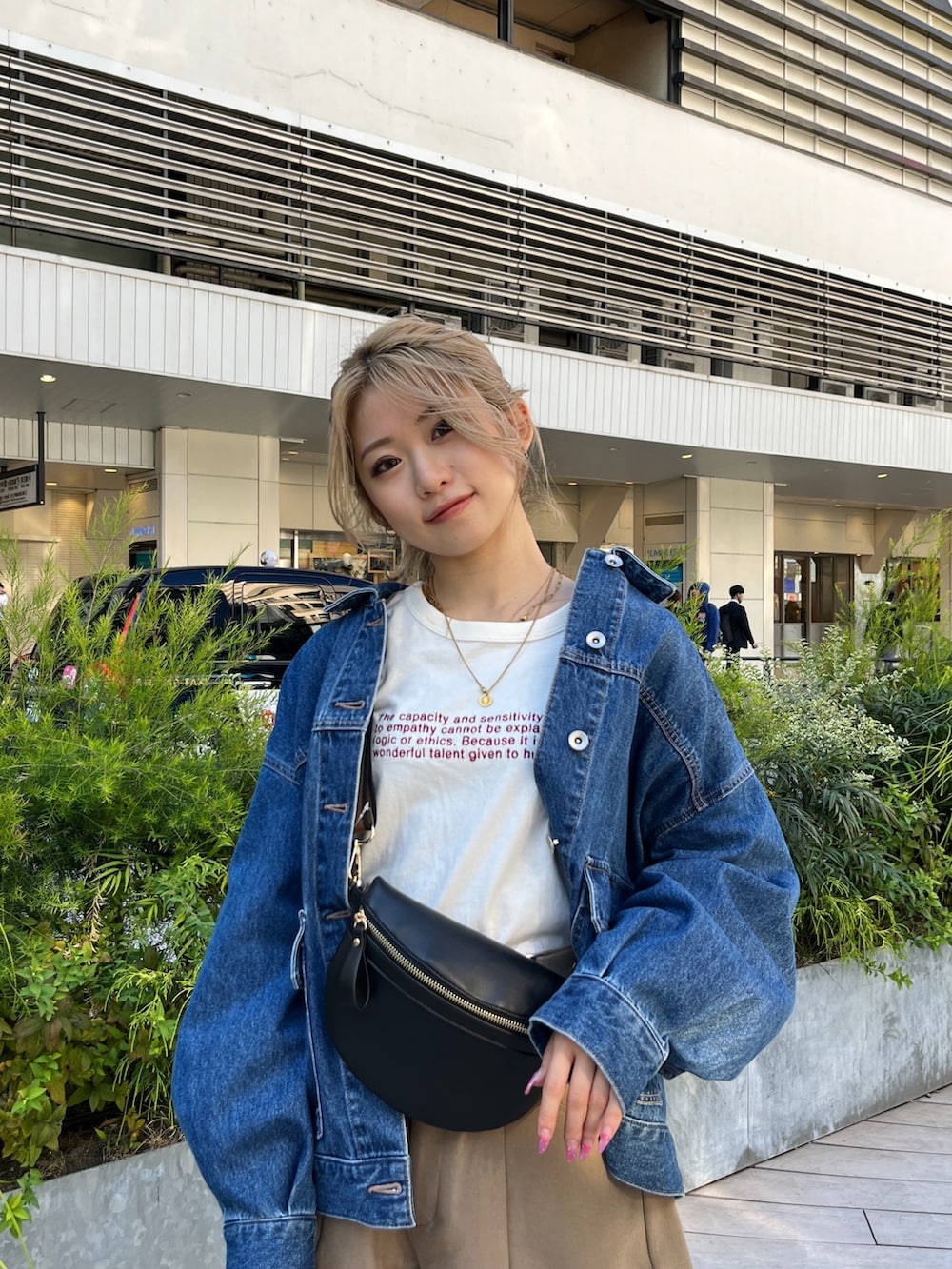 ブルー系のデニムジャケット、ホワイト系のTシャツ/カットソー、ブラック系のボディバッグ/ウエストポーチを着用したレディースの秋コーディネートの7枚目の写真