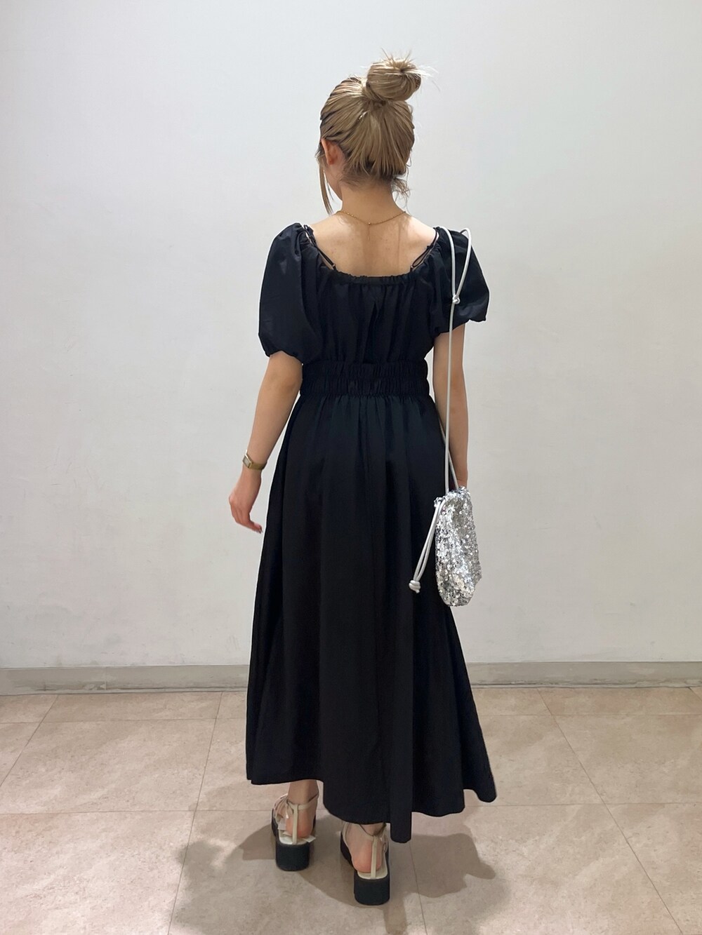 ブラック系のワンピース、シルバー系のハンドバッグ、ホワイト系のサンダルを着用したレディースの春コーディネートの9枚目の写真