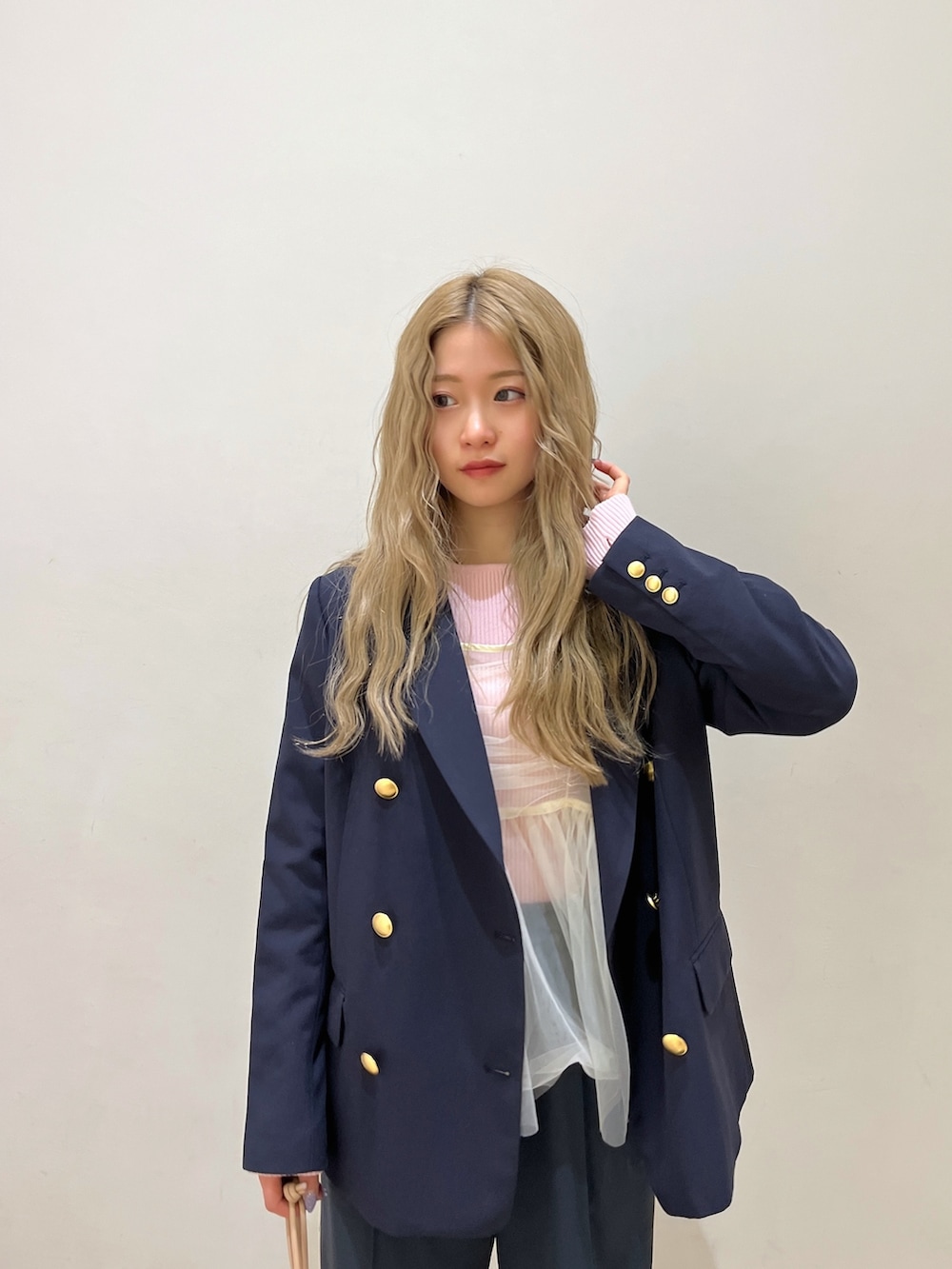 ブルー系のテーラードジャケット、ピンク系のニット/セーター、シルバー系のハンドバッグを着用したレディースの冬コーディネートの5枚目の写真