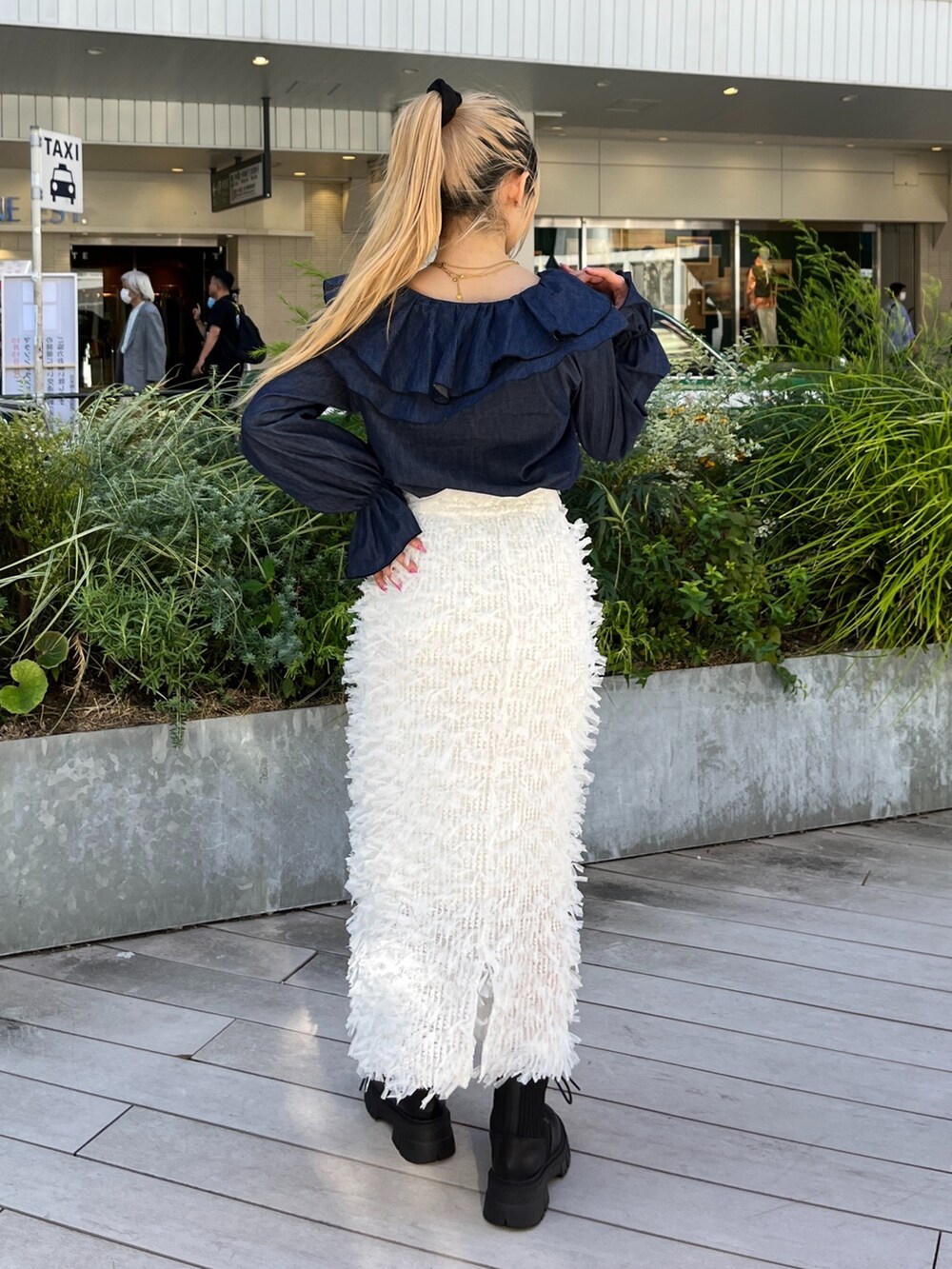 ホワイト系のスカート、ブルー系のシャツ/ブラウス、ブラック系のブーツを着用したレディースの秋コーディネートの3枚目の写真