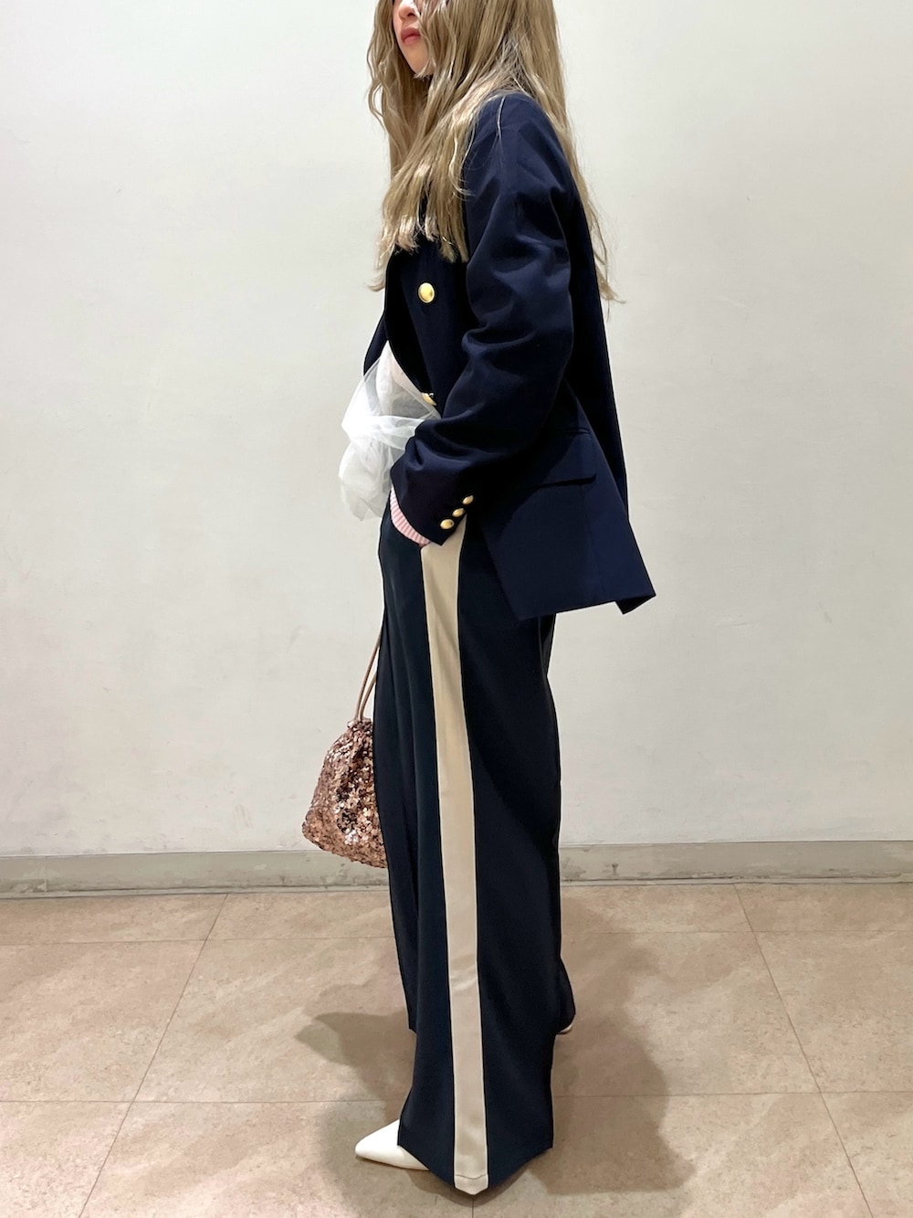 ブルー系のテーラードジャケット、ピンク系のニット/セーター、シルバー系のハンドバッグを着用したレディースの冬コーディネートの3枚目の写真