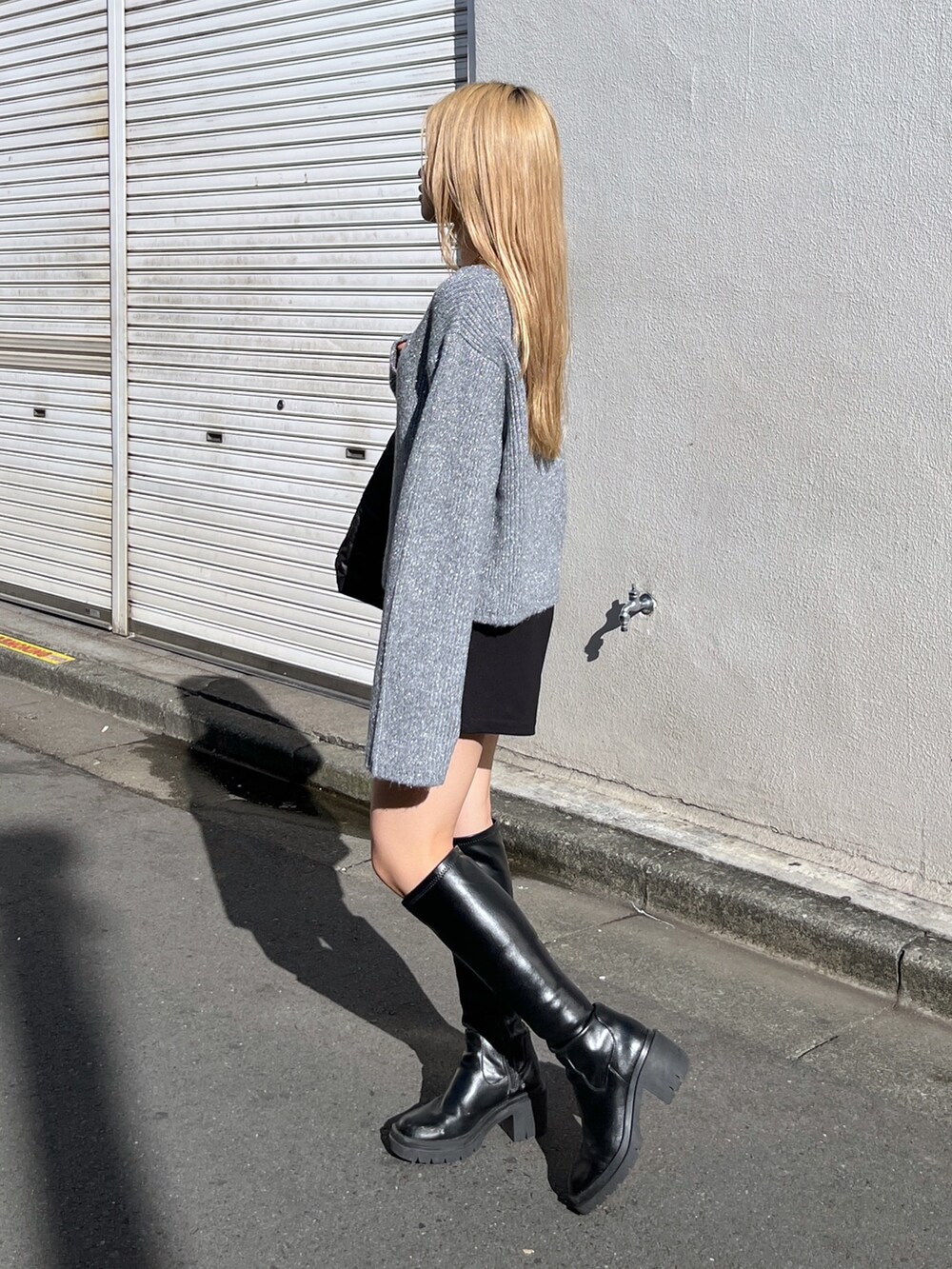 ブラック系のその他パンツ、ブラック系のブーツ、ブラック系のトートバッグを着用したレディースの冬コーディネートの2枚目の写真