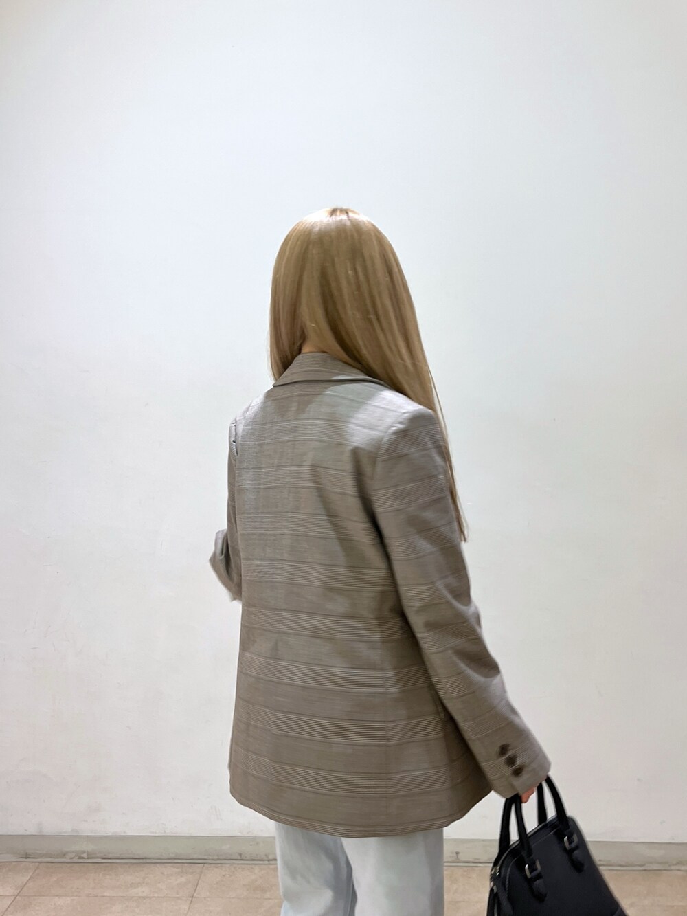 ブラック系のショルダーバッグ、ブルー系のデニムパンツ、ブラック系のパンプスを着用したレディースの春コーディネートの8枚目の写真