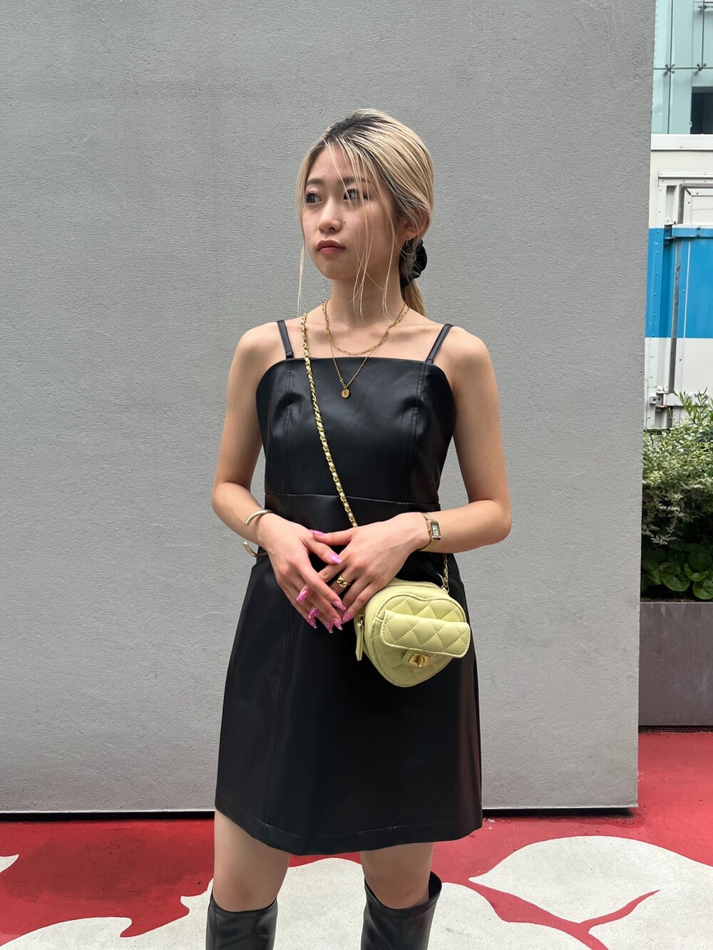 ブラック系のブーツ、ブラック系のワンピース、イエロー系のショルダーバッグを着用したレディースの秋コーディネートの7枚目の写真