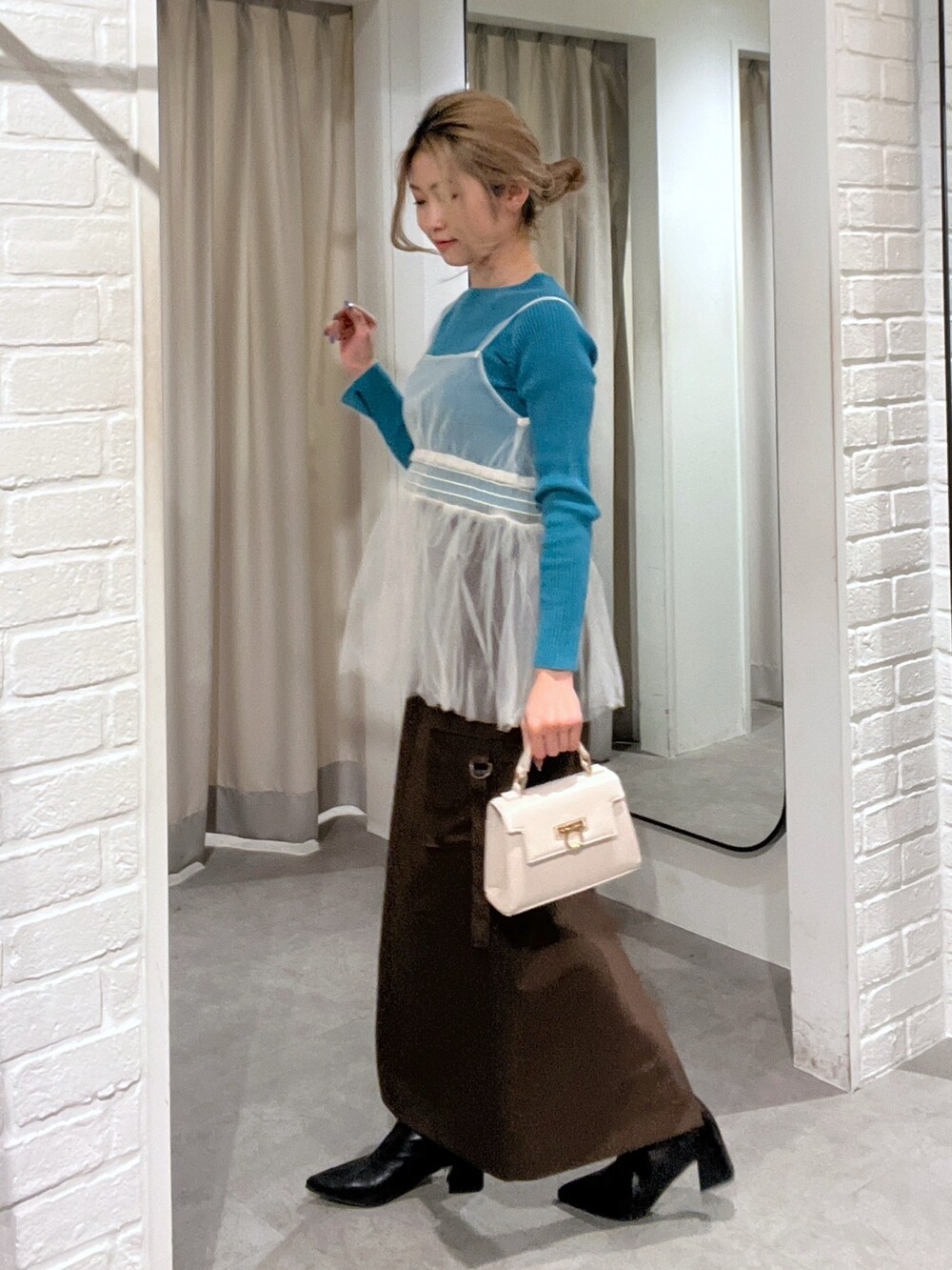 ブラウン系のスカート、ホワイト系のシャツ/ブラウス、ホワイト系のショルダーバッグを着用したレディースの冬コーディネートの2枚目の写真