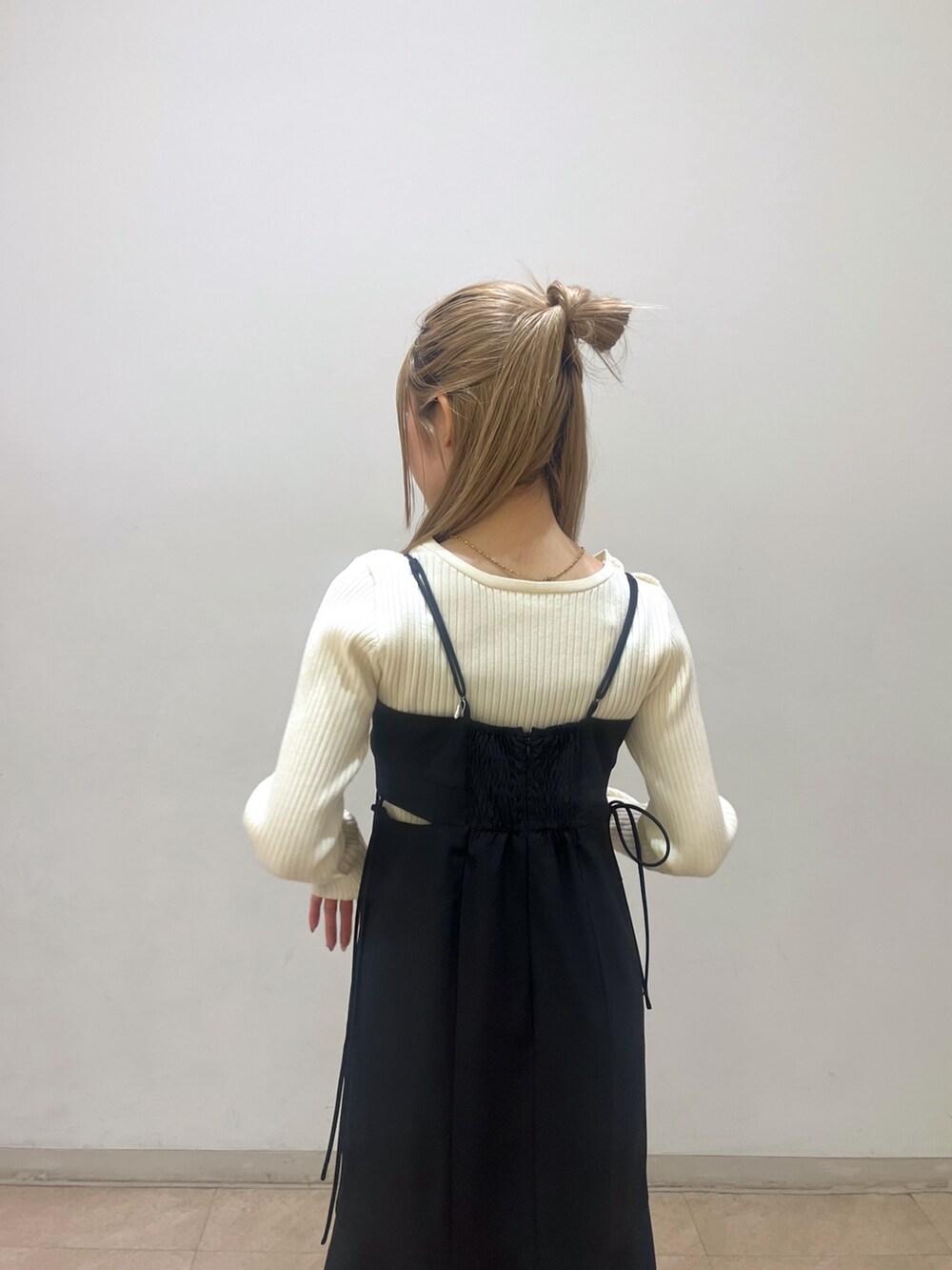 ホワイト系のニット/セーター、ブラック系のワンピース、ホワイト系のトートバッグを着用したレディースの春コーディネートの7枚目の写真