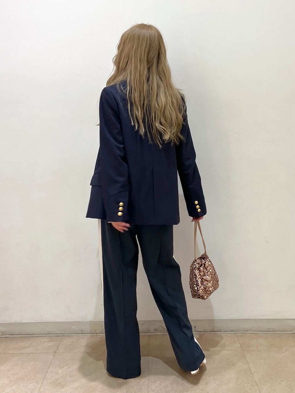 ブルー系のテーラードジャケット、ピンク系のニット/セーター、シルバー系のハンドバッグを着用したレディースの冬コーディネートの2枚目の写真