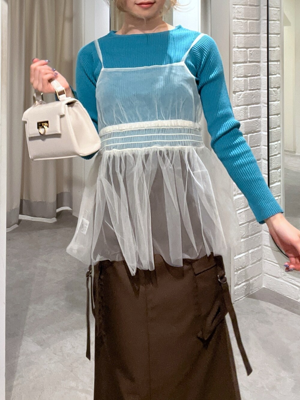 ブラウン系のスカート、ホワイト系のシャツ/ブラウス、ホワイト系のショルダーバッグを着用したレディースの冬コーディネートの7枚目の写真