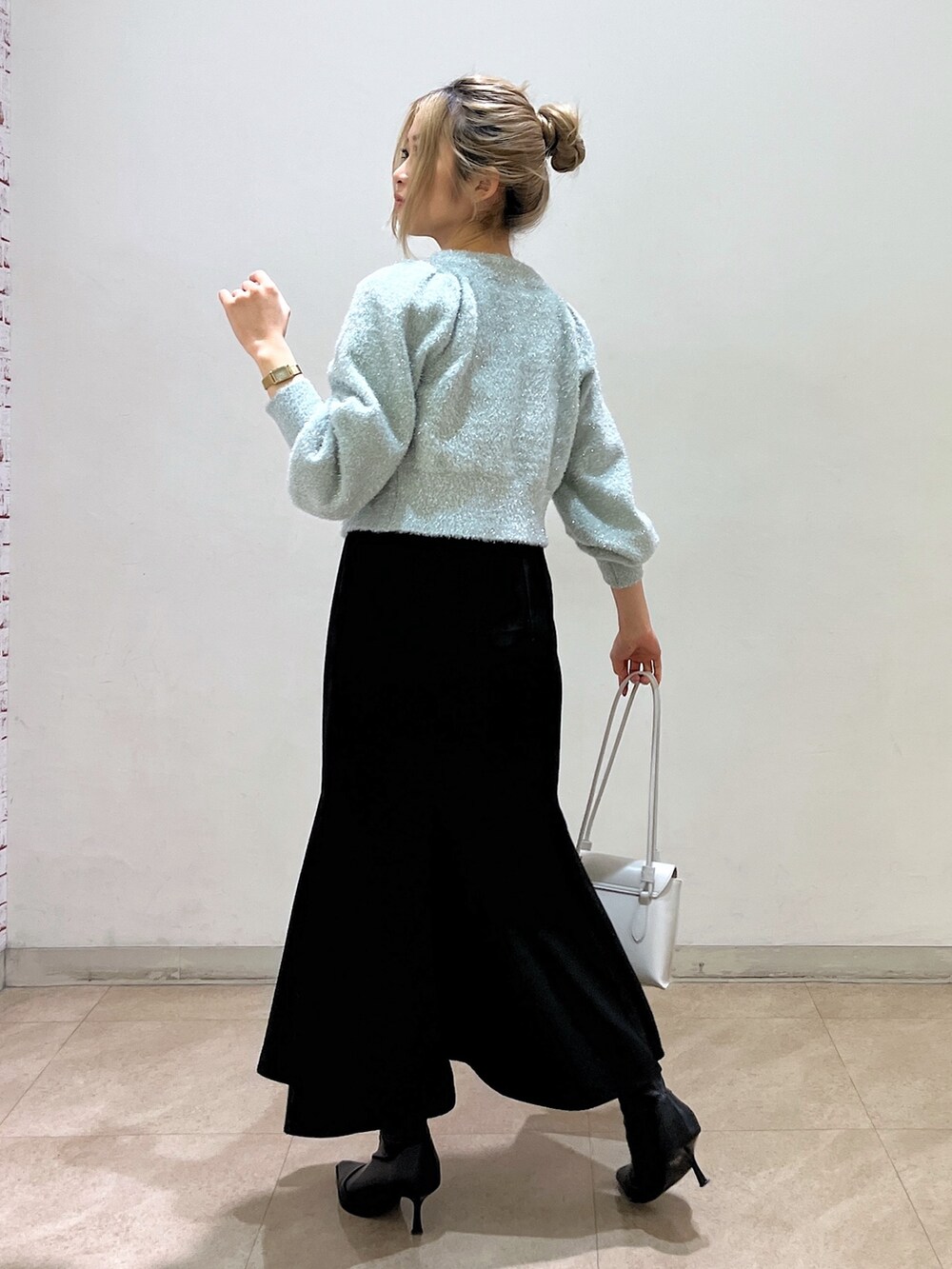 グリーン系のカーディガン/ボレロ、ホワイト系のショルダーバッグ、ブラック系のワンピースを着用したレディースの冬コーディネートの7枚目の写真