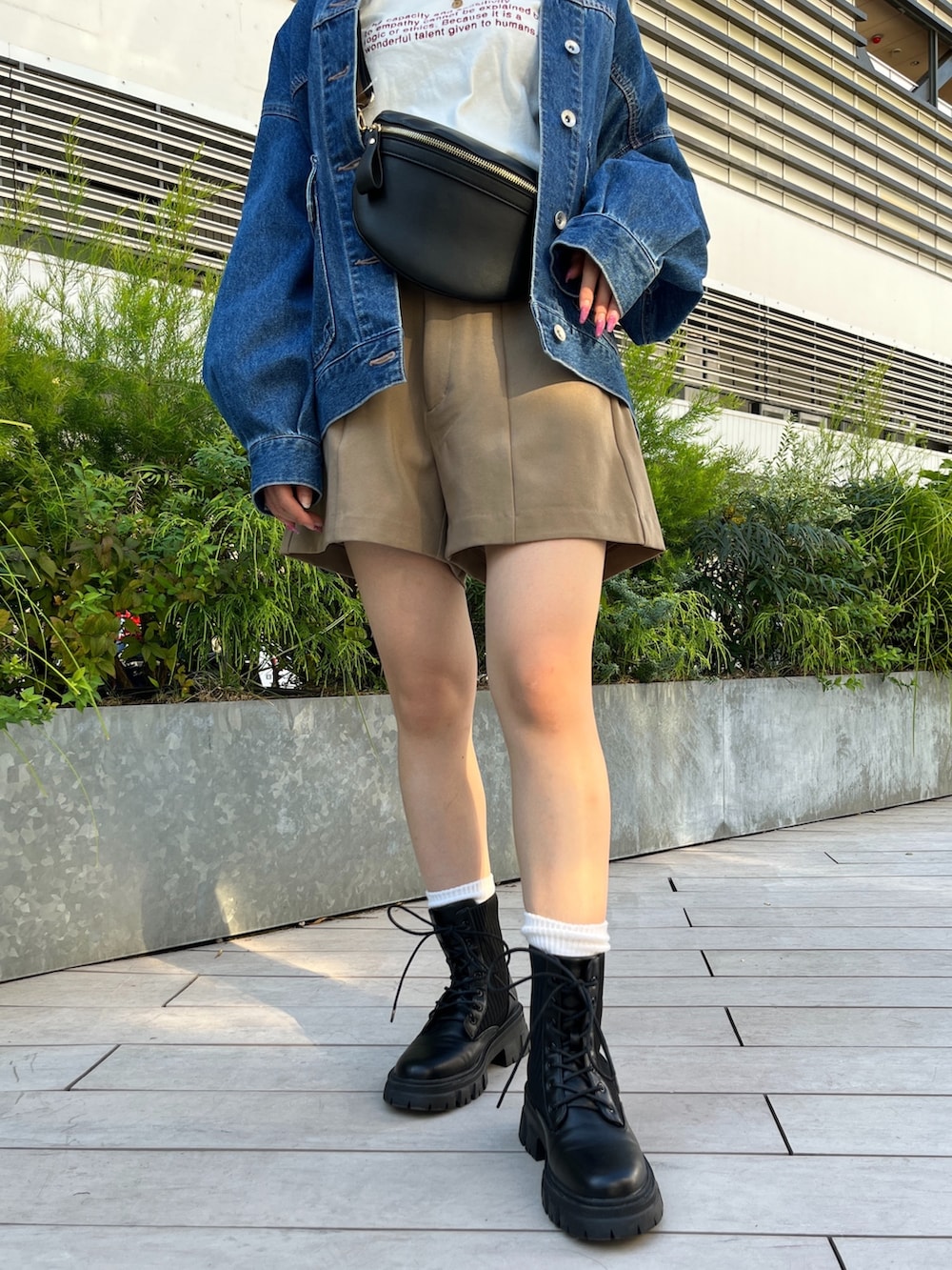 ブルー系のデニムジャケット、ホワイト系のTシャツ/カットソー、ブラック系のボディバッグ/ウエストポーチを着用したレディースの秋コーディネートの9枚目の写真