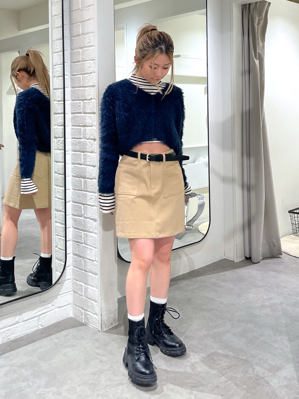 ブルー系のカーディガン/ボレロ、ホワイト系のニット/セーター、ブラック系のブーツを着用したレディースの冬コーディネートの4枚目の写真