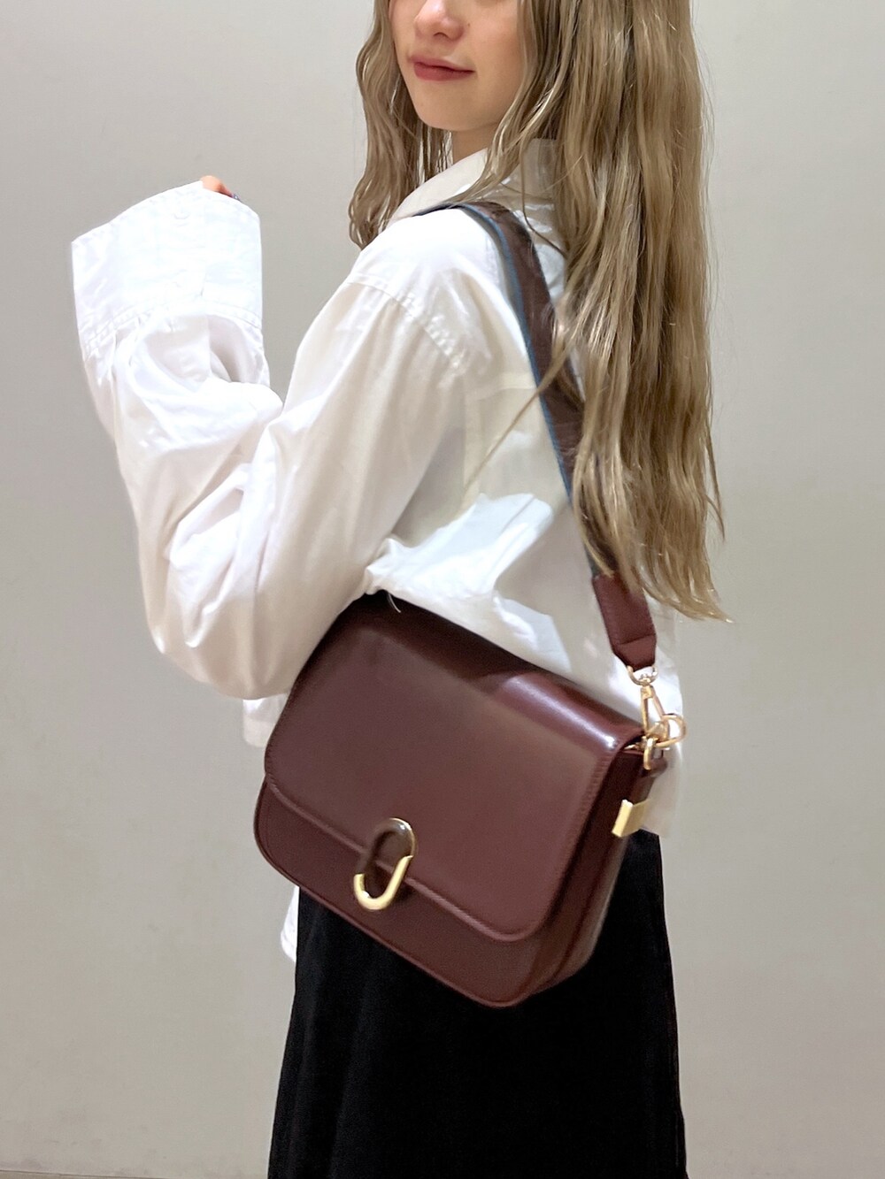 ブラック系のスカート、ホワイト系のシャツ/ブラウス、ブラウン系のショルダーバッグを着用したレディースの春コーディネートの8枚目の写真