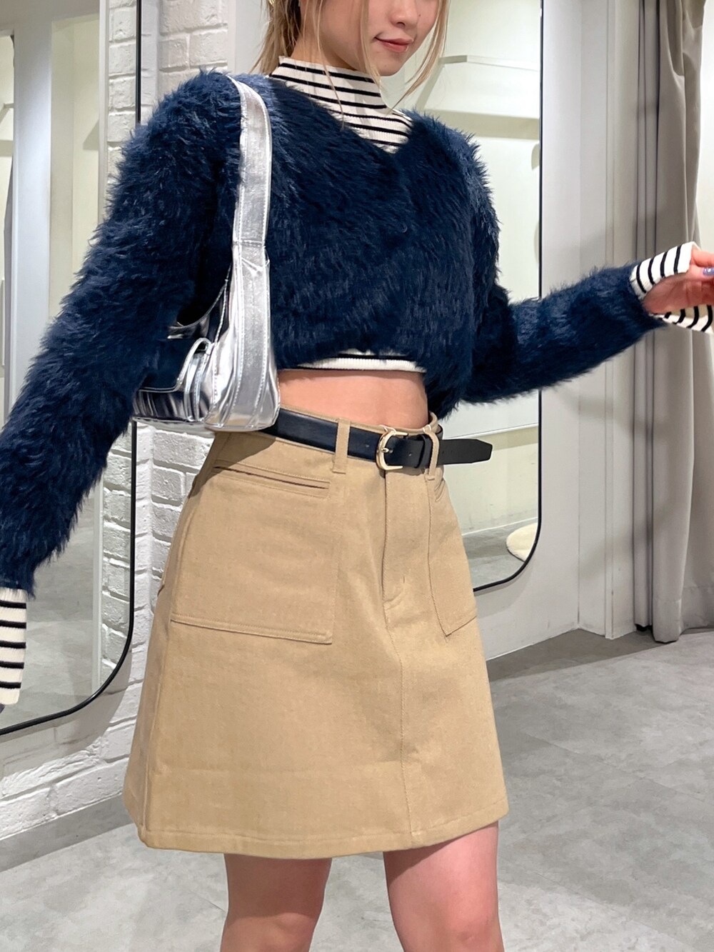 ブルー系のカーディガン/ボレロ、ホワイト系のニット/セーター、ブラック系のブーツを着用したレディースの冬コーディネートの6枚目の写真