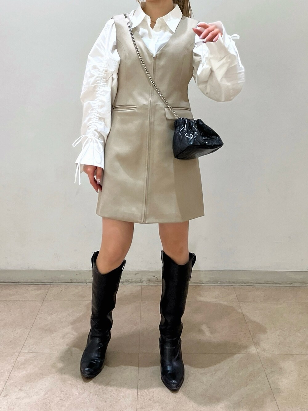 ブラック系のショルダーバッグ、ホワイト系のシャツ/ブラウス、ベージュ系のワンピースを着用したレディースの春コーディネートの8枚目の写真