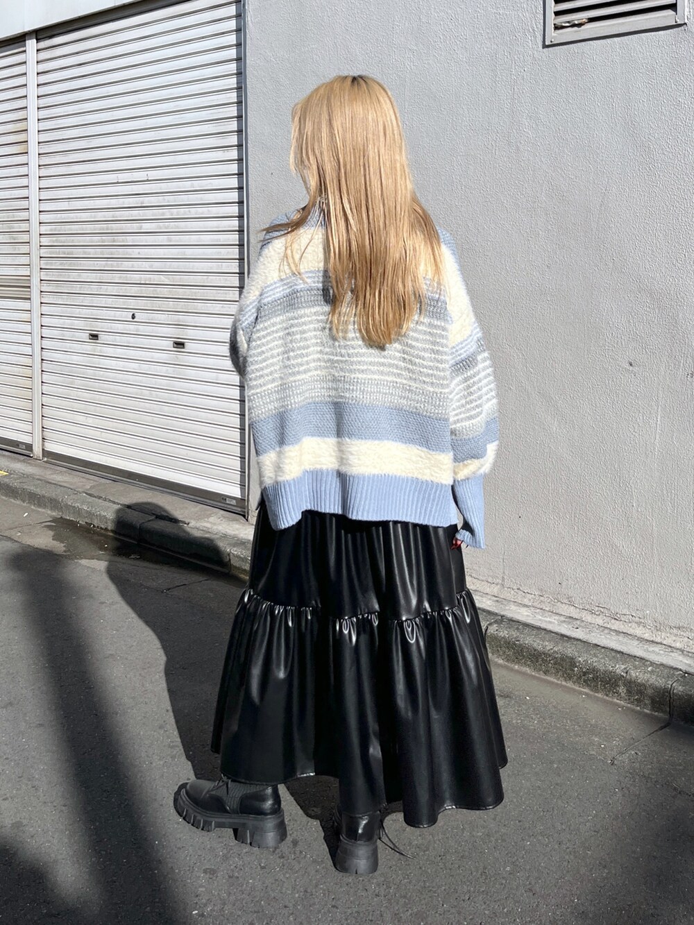 ブルー系のニット/セーター、ブラック系のスカート、ブラック系のブーツを着用したレディースの冬コーディネートの3枚目の写真