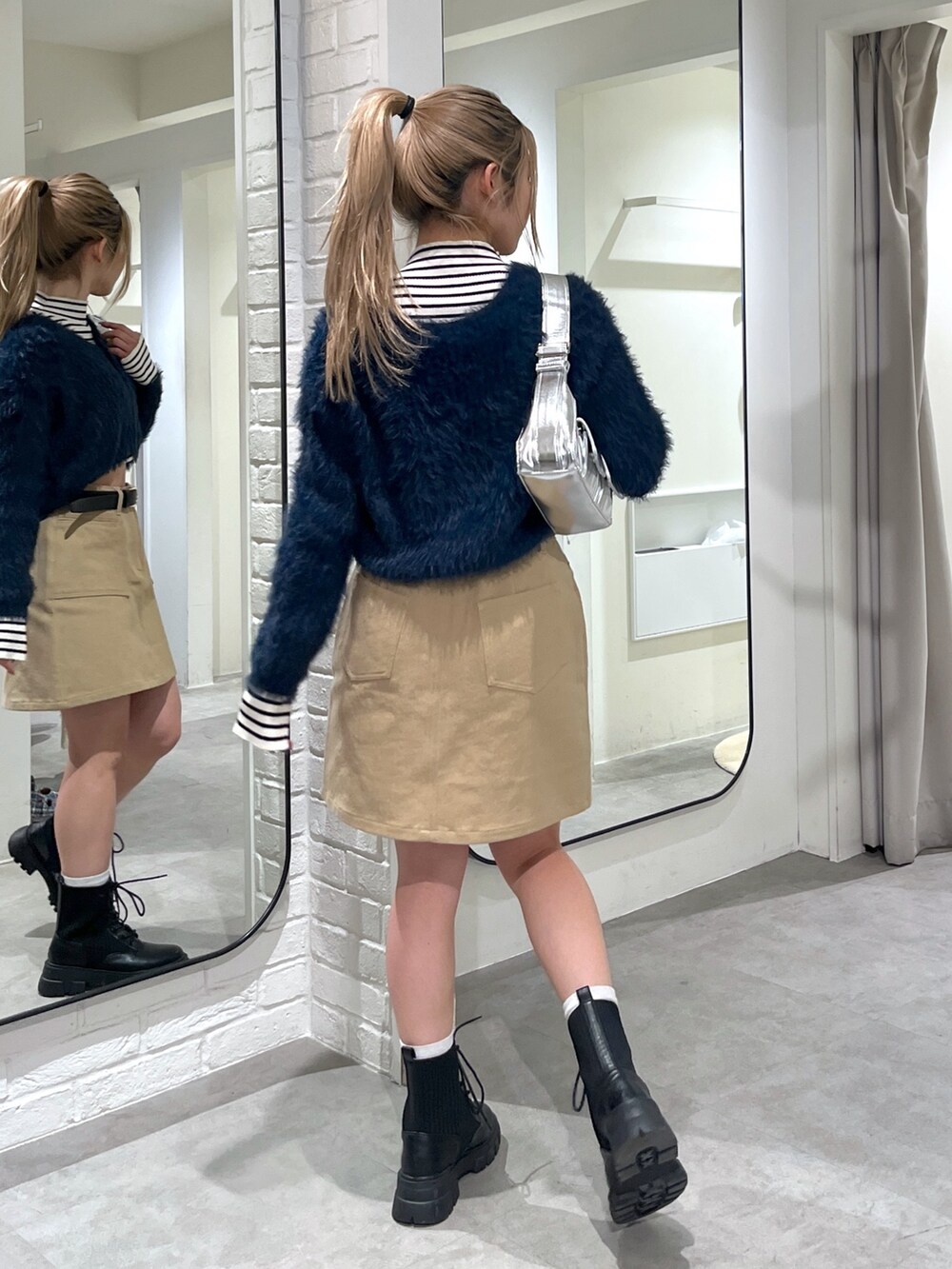 ブルー系のカーディガン/ボレロ、ホワイト系のニット/セーター、ブラック系のブーツを着用したレディースの冬コーディネートの3枚目の写真