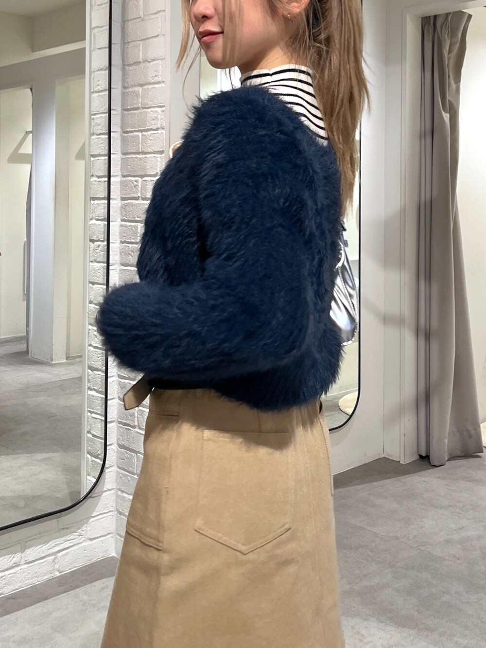 ブルー系のカーディガン/ボレロ、ホワイト系のニット/セーター、ブラック系のブーツを着用したレディースの冬コーディネートの7枚目の写真