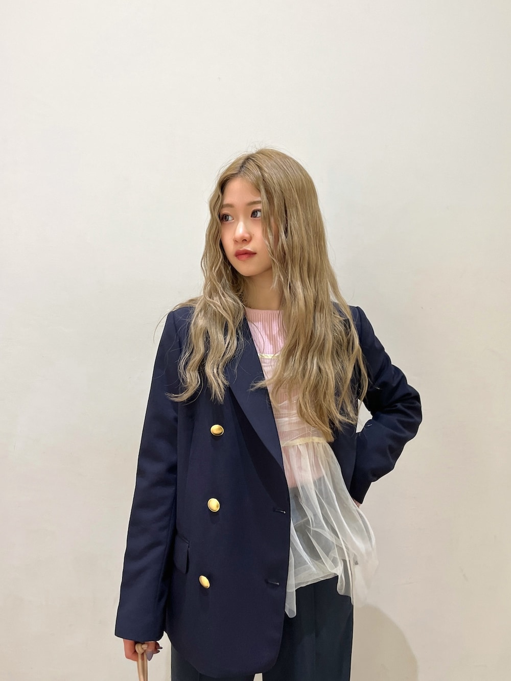 ブルー系のテーラードジャケット、ピンク系のニット/セーター、シルバー系のハンドバッグを着用したレディースの冬コーディネートの4枚目の写真