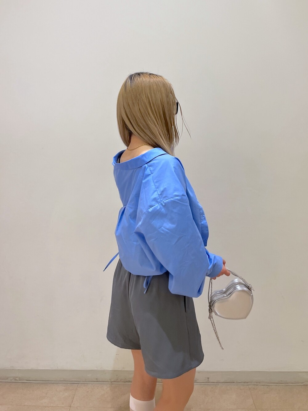 ブルー系のシャツ/ブラウス、グレー系のスカート、シルバー系のショルダーバッグを着用したレディースの春コーディネートの8枚目の写真