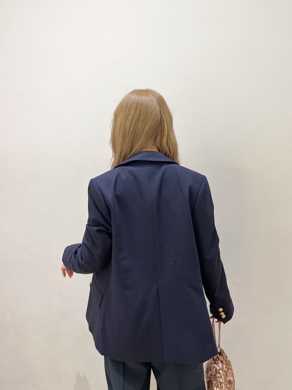 ブルー系のテーラードジャケット、ピンク系のニット/セーター、シルバー系のハンドバッグを着用したレディースの冬コーディネートの7枚目の写真