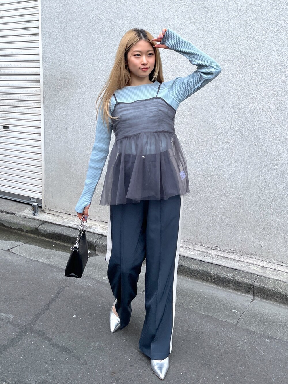 ブルー系のニット/セーター、ブラック系のショルダーバッグ、グレー系のシャツ/ブラウスを着用したレディースの冬コーディネートの2枚目の写真