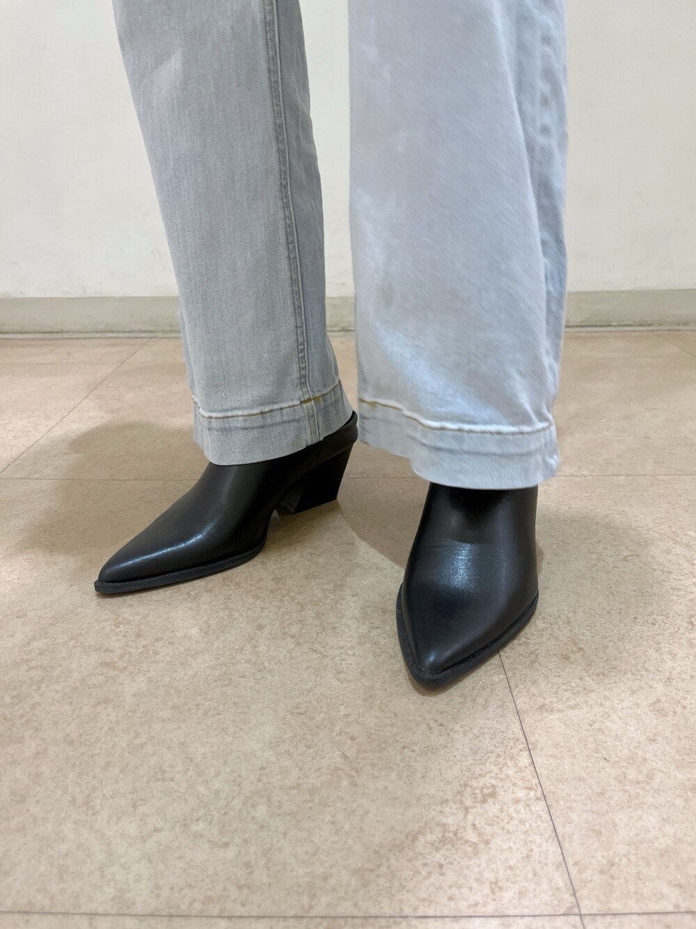 ホワイト系のカーディガン/ボレロ、ブルー系のデニムパンツ、ブラック系のショルダーバッグを着用したレディースの春コーディネートの9枚目の写真