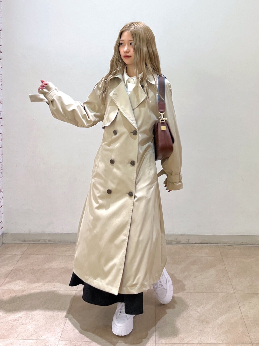 ホワイト系のシャツ/ブラウス、ベージュ系のトレンチコート、ブラウン系のショルダーバッグを着用したレディースの春コーディネートの7枚目の写真