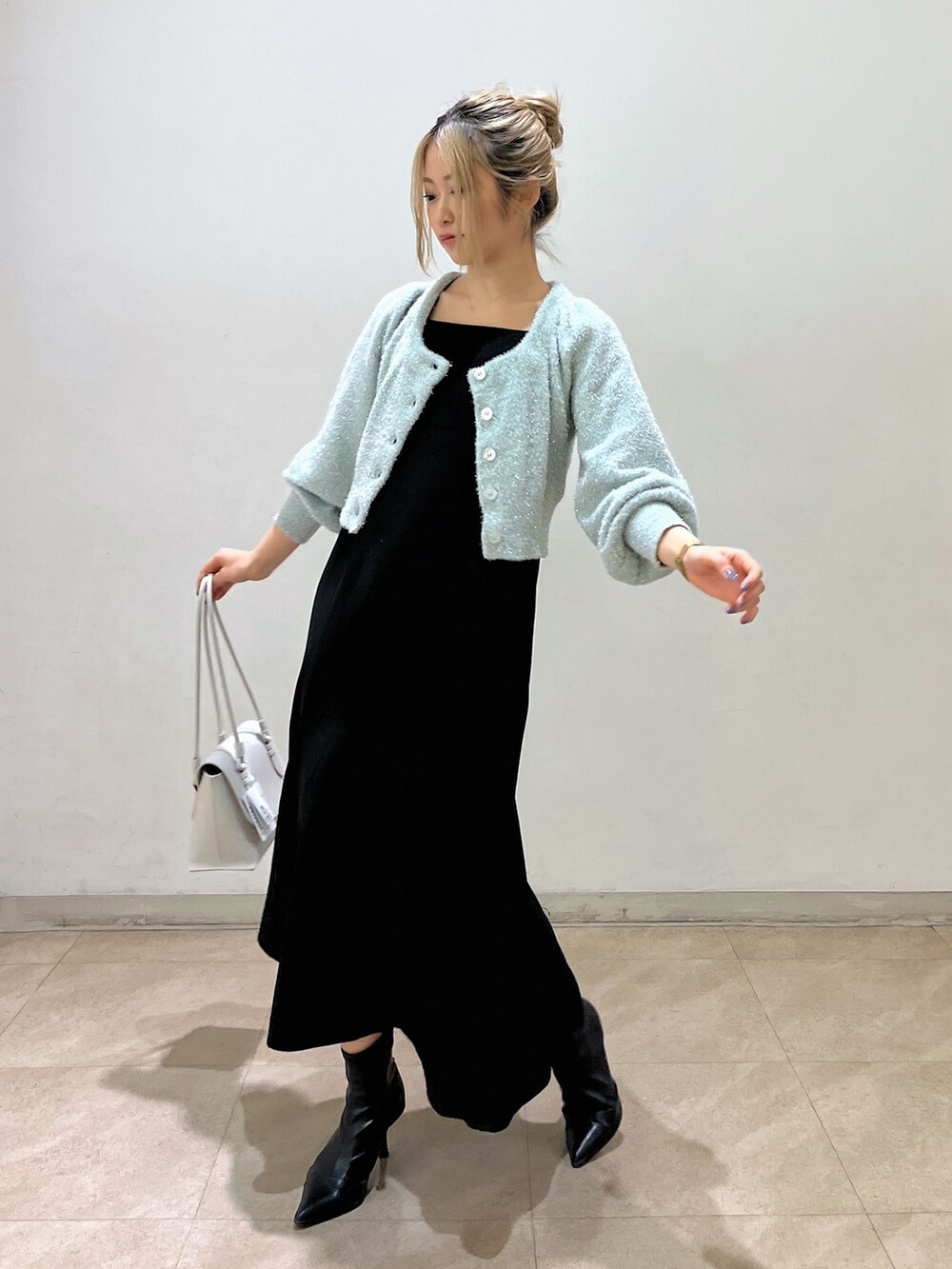 グリーン系のカーディガン/ボレロ、ホワイト系のショルダーバッグ、ブラック系のワンピースを着用したレディースの冬コーディネートの2枚目の写真