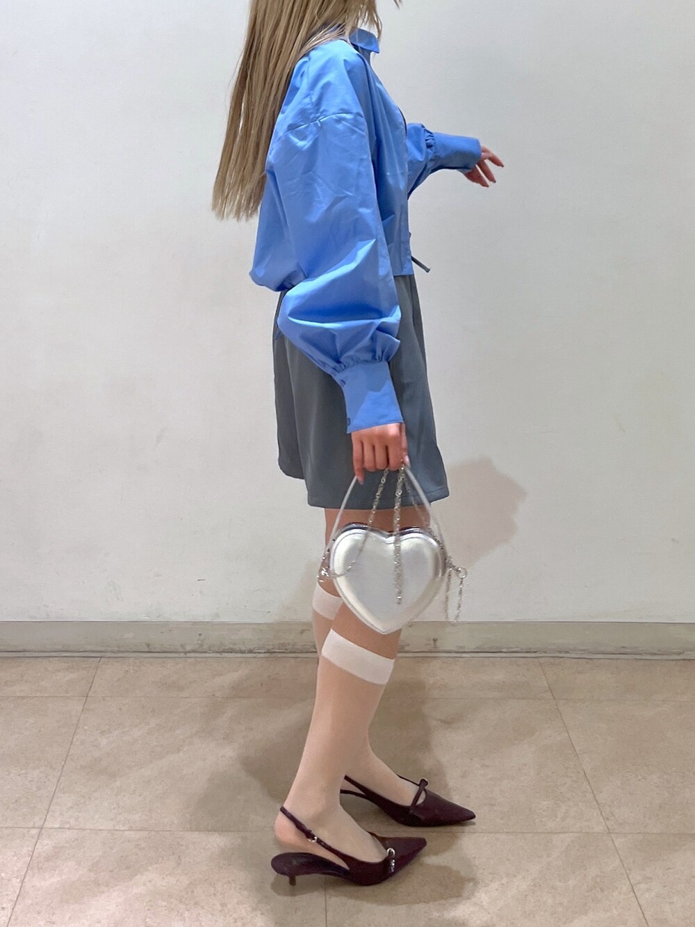 ブルー系のシャツ/ブラウス、グレー系のスカート、シルバー系のショルダーバッグを着用したレディースの春コーディネートの4枚目の写真
