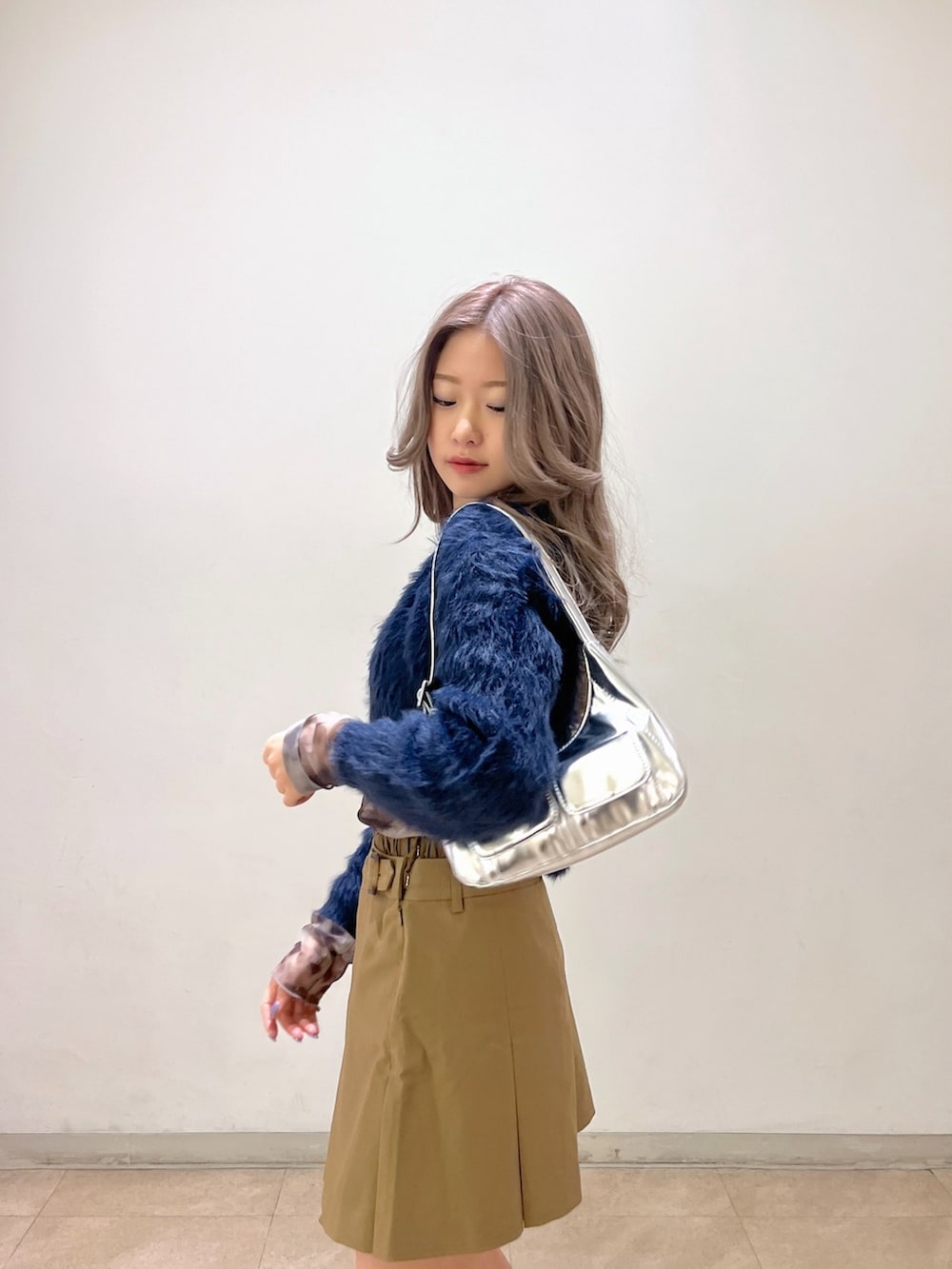 グレー系のTシャツ/カットソー、シルバー系のショルダーバッグ、ブルー系のカーディガン/ボレロを着用したレディースの冬コーディネートの7枚目の写真