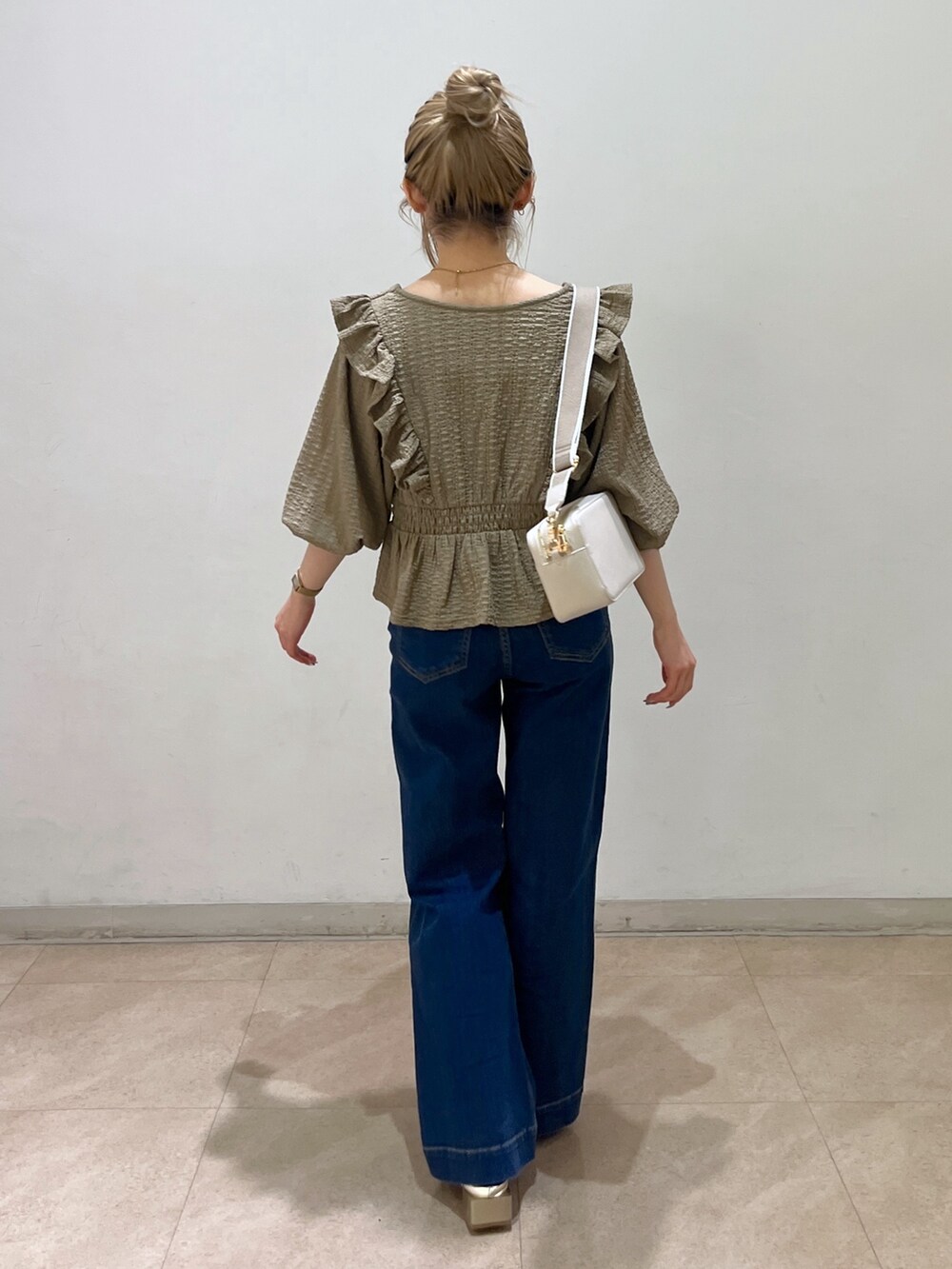 ブラウン系のシャツ/ブラウス、ブルー系のデニムパンツ、ゴールド系のパンプスを着用したレディースの春コーディネートの4枚目の写真