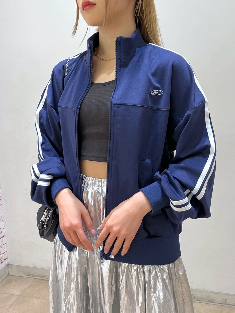 ブルー系のブルゾン、ブラック系のショルダーバッグ、シルバー系のスカートを着用したレディースの春コーディネートの8枚目の写真