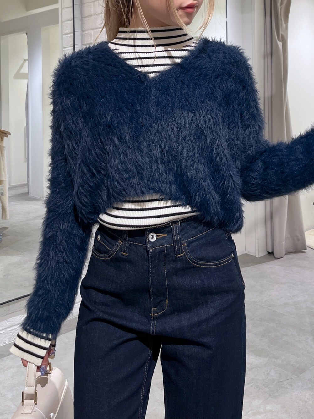 ホワイト系のニット/セーター、ブルー系のカーディガン/ボレロ、ホワイト系のショルダーバッグを着用したレディースの冬コーディネートの10枚目の写真