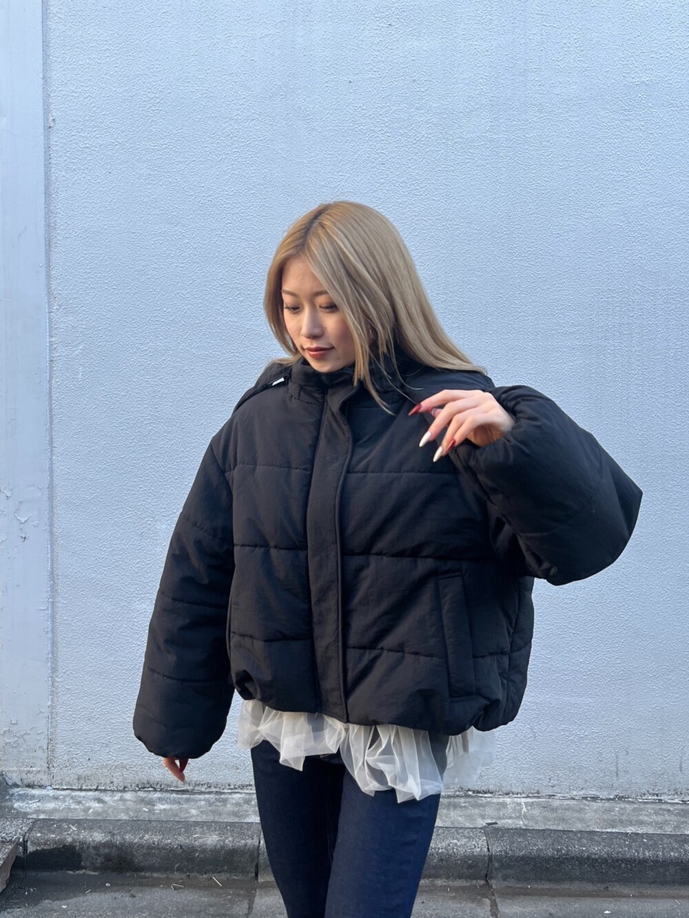 ホワイト系のシャツ/ブラウス、グレー系のニット/セーター、ブルー系のデニムパンツを着用したレディースの冬コーディネートの8枚目の写真