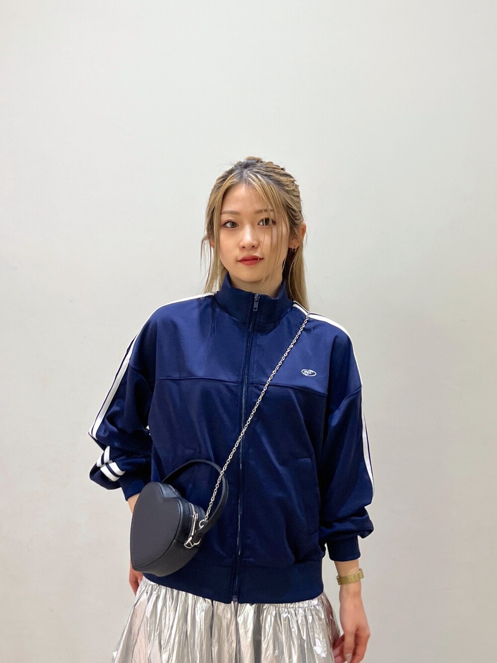 ブルー系のブルゾン、ブラック系のショルダーバッグ、シルバー系のスカートを着用したレディースの春コーディネートの5枚目の写真