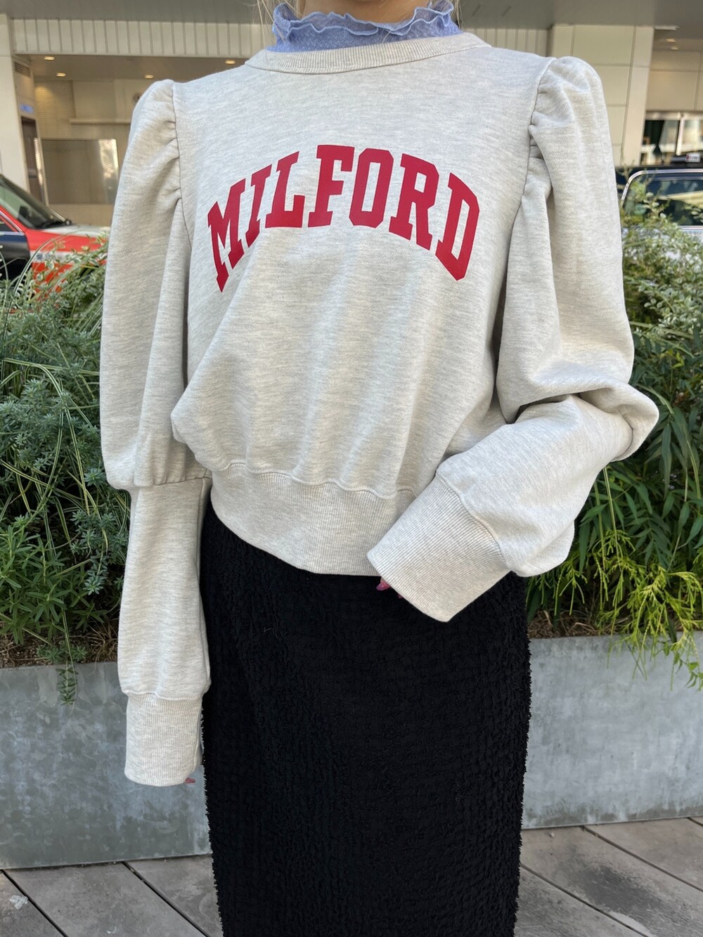 ホワイト系のスウェット、ホワイト系のブーツ、ブラック系のスカートを着用したレディースの秋コーディネートの8枚目の写真