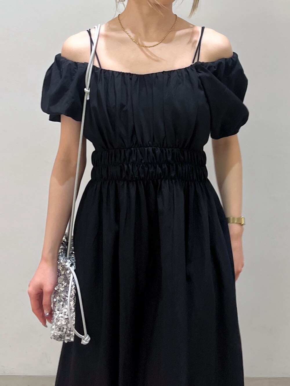 ブラック系のワンピース、シルバー系のハンドバッグ、ホワイト系のサンダルを着用したレディースの春コーディネートの7枚目の写真