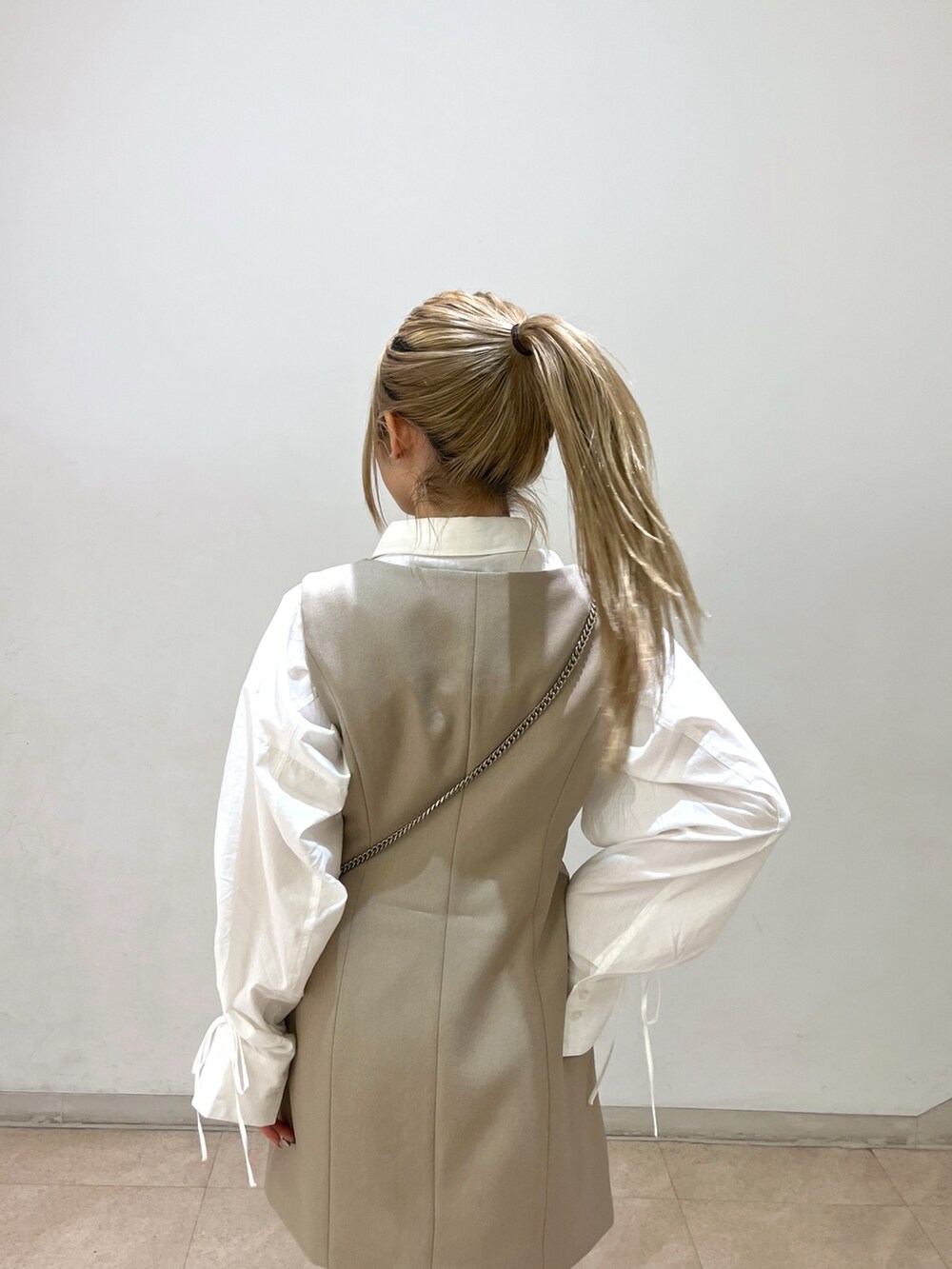 ブラック系のショルダーバッグ、ホワイト系のシャツ/ブラウス、ベージュ系のワンピースを着用したレディースの春コーディネートの7枚目の写真