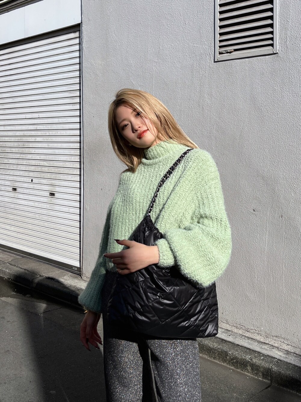 ブラック系のブーツ、ブラック系のその他パンツ、グリーン系のニット/セーターを着用したレディースの冬コーディネートの7枚目の写真